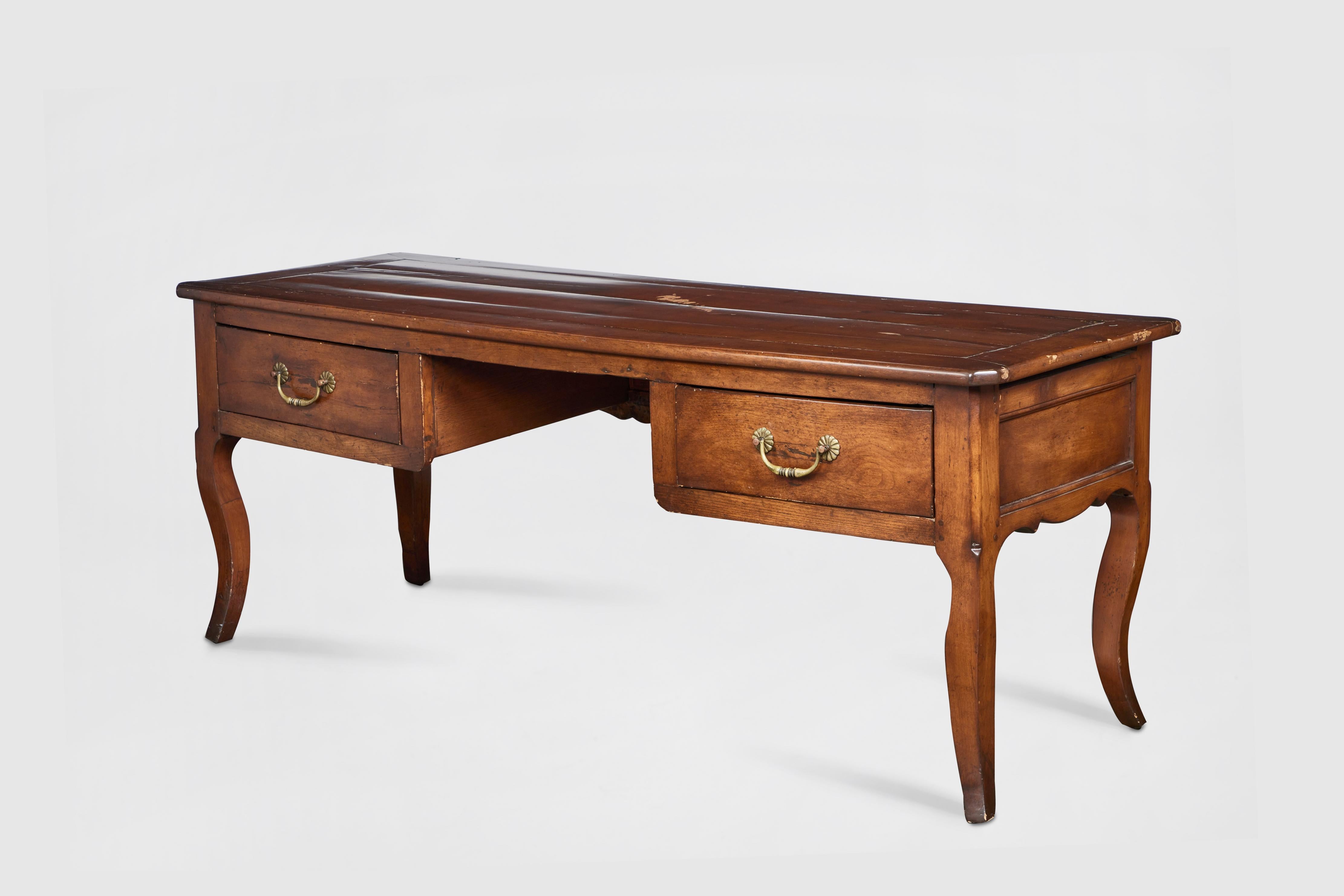 19th C. Antique Louis XV Style French oak desk with two drawers and original hardware. Its carved back and side aprons and sabre legs lend a regal standing to this piece. 

Additional Dimensions: 
Drawers 6