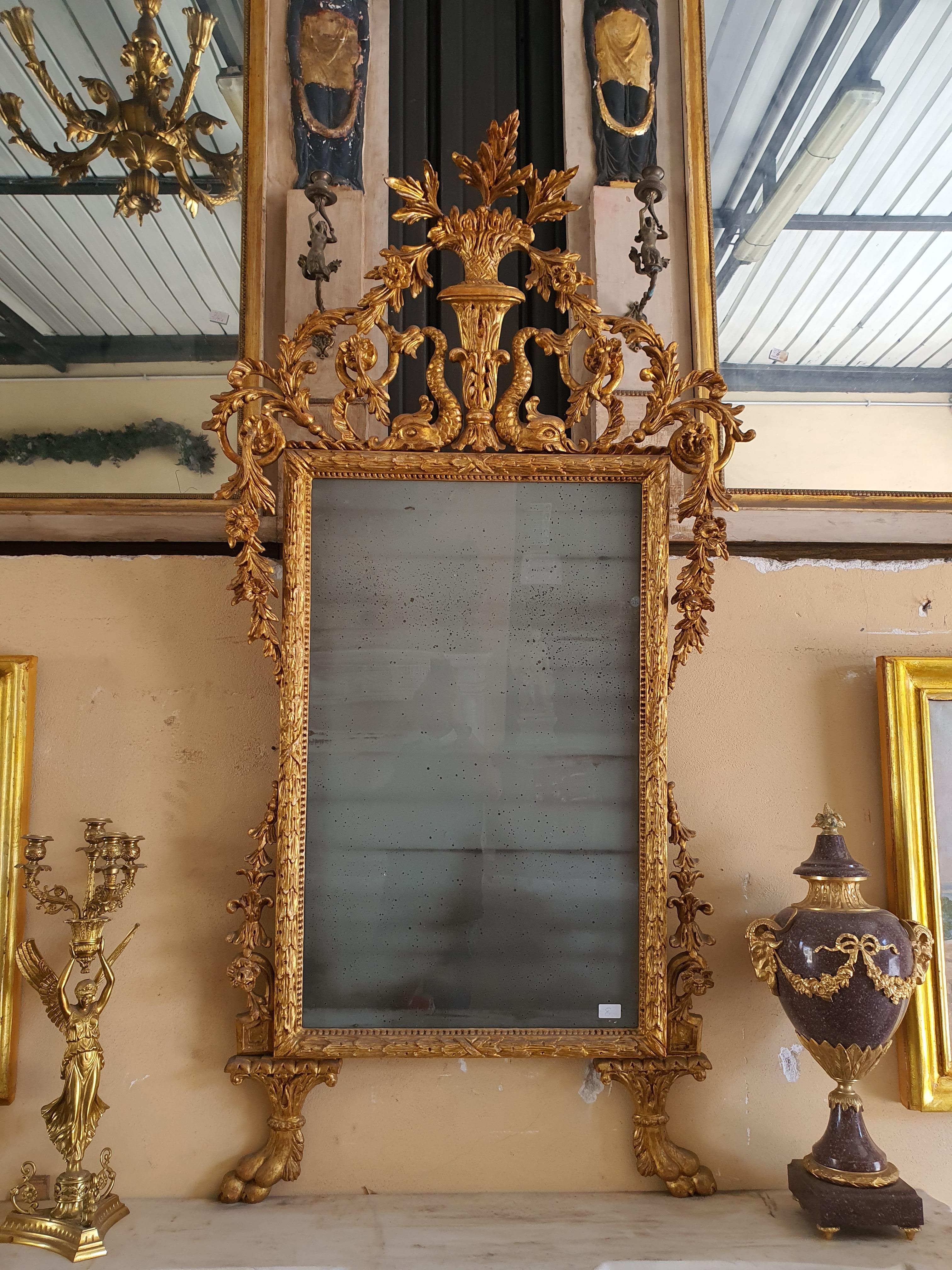 Mirror in carved and gilded wood, Louis XVI style, made in the 19th century in Italy. Provenance Lucca. Valuable carving work.