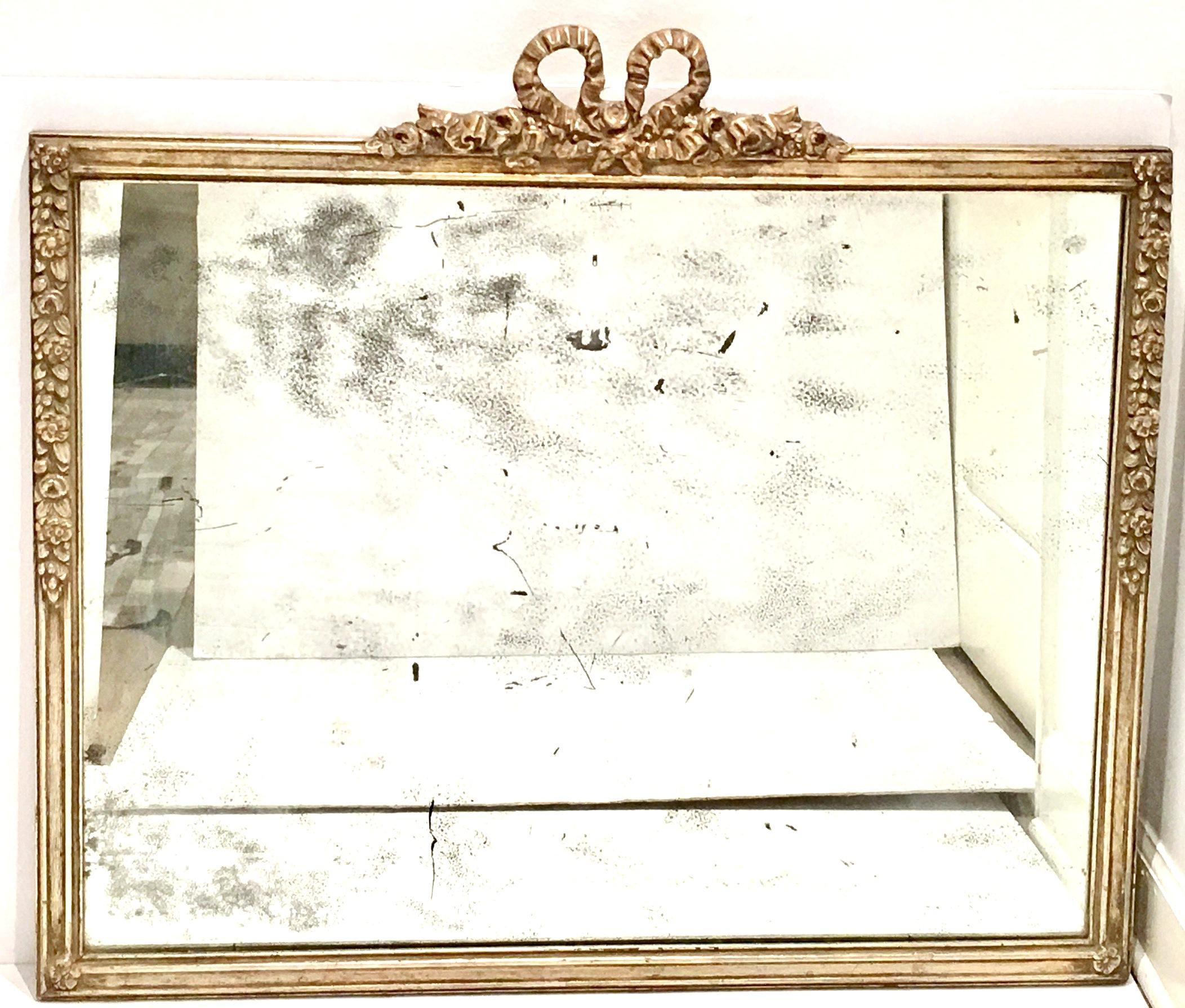 19th Century Antique Louis XVI style silver leaf carved wood mirror. Original heavy mirror with coveted antique wear and patina. Hand Carved high relief wood with authentic silver leaf finish, floral motif with a central crown ornament in the French