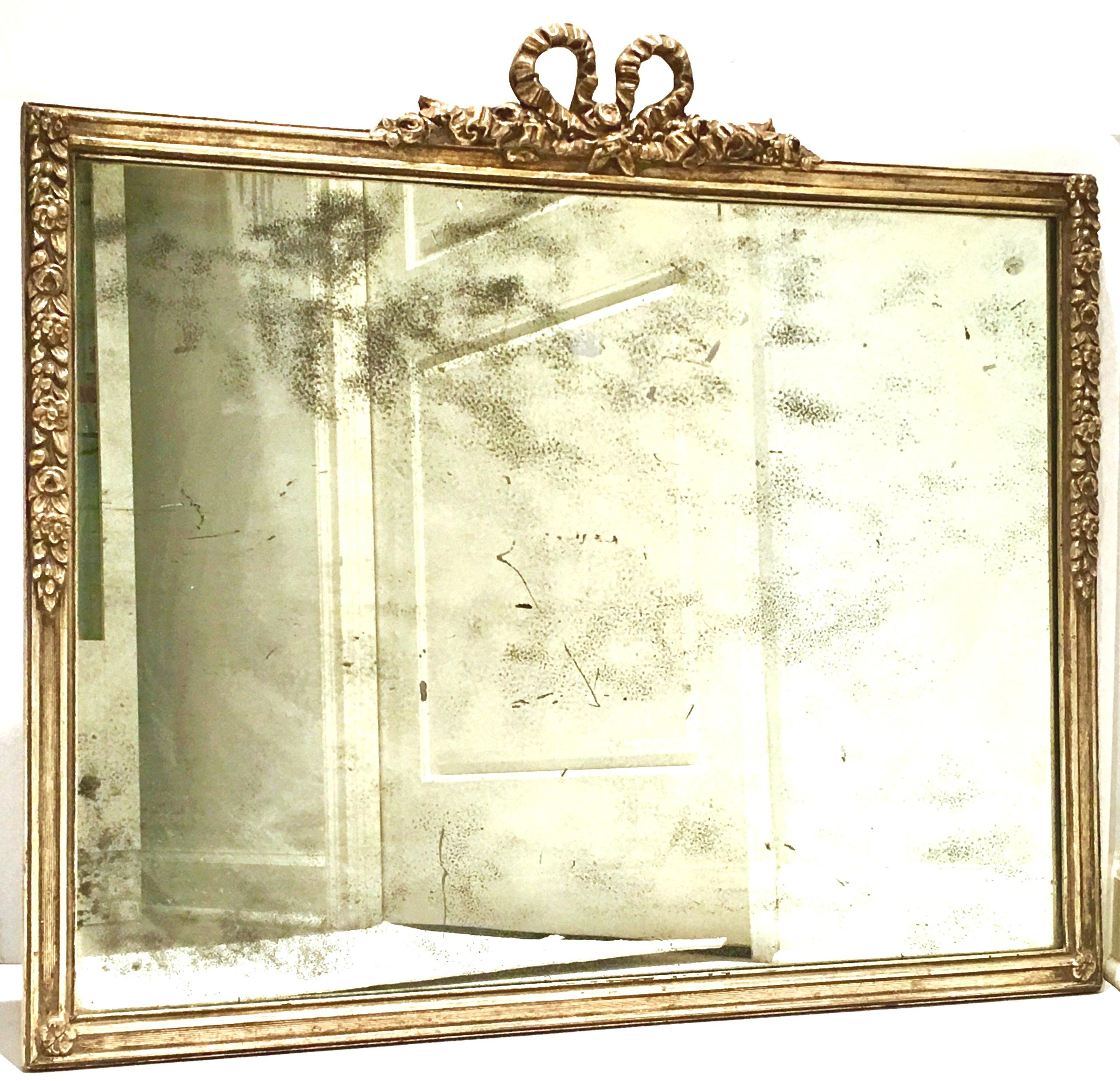 19th century antique Louis XVI style silver leaf hand carved wood mirror. Original heavy mirror with coveted and authentic antique wear and patina. Hand carved high relief wood with authentic silver leaf finish, floral motif with a central crown