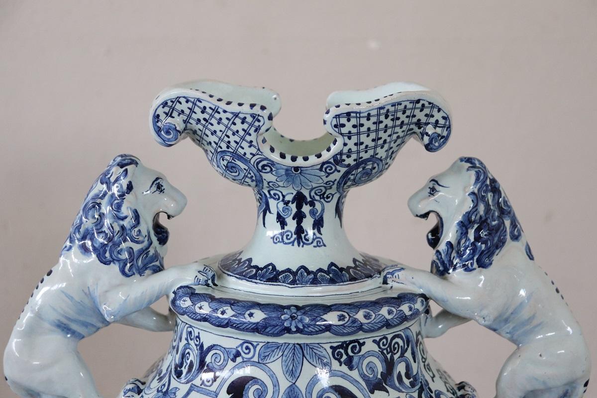 Ti presentiamo questo fantastico vaso antico di grandi dimensioni realizzato in maiolica nel XIX secolo. Il vaso è caratterizzato da una raffinata decorazione a smalto nei toni del blu. L'attenzione è sicuramente catturata dai due leoni che decorano