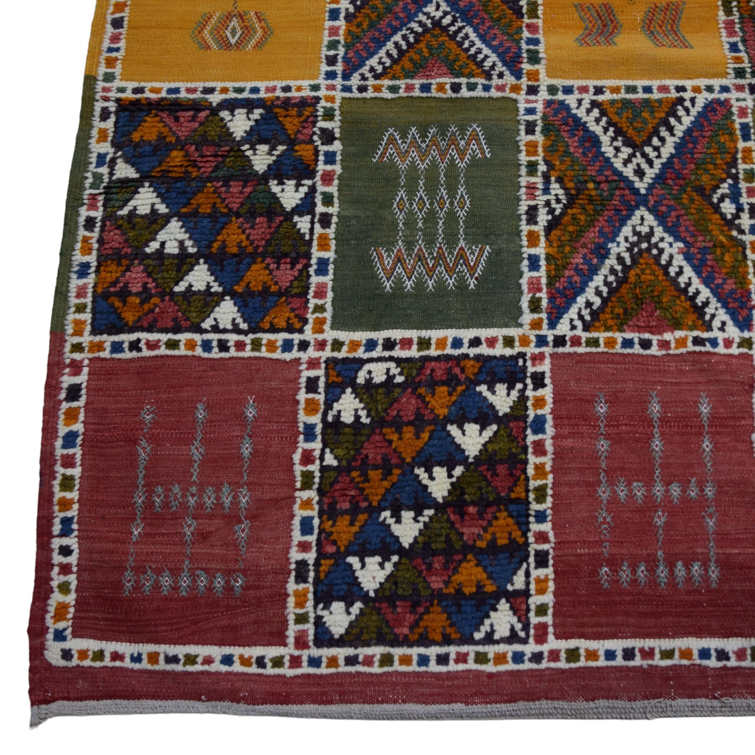 Le tapis marocain ancien du XIXe siècle que vous tenez entre les mains est une pièce de collection unique avec ses détails élégants et sa fabrication artisanale. Ce tapis se compose de carrés décorés de motifs géométriques colorés et variés, et les