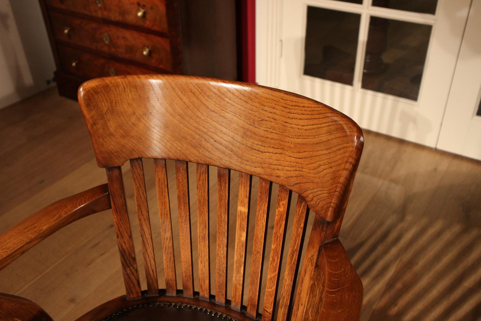 Antique oak office chair in perfect condition. The seat is newly upholstered in brown leather. The chair has seat-height adjustment and a rocking mechanism. Can be equipped with smooth rolling casters, especially for parquet flooring, instead of the