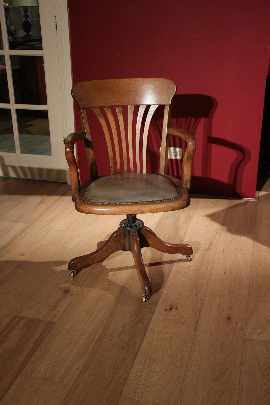 Antique oak office chair in original condition. The chair has seat-height adjustment and a rocking mechanism. Can be equipped with smooth rolling casters, especially for parquet flooring, instead of the original iron casters that are on now.