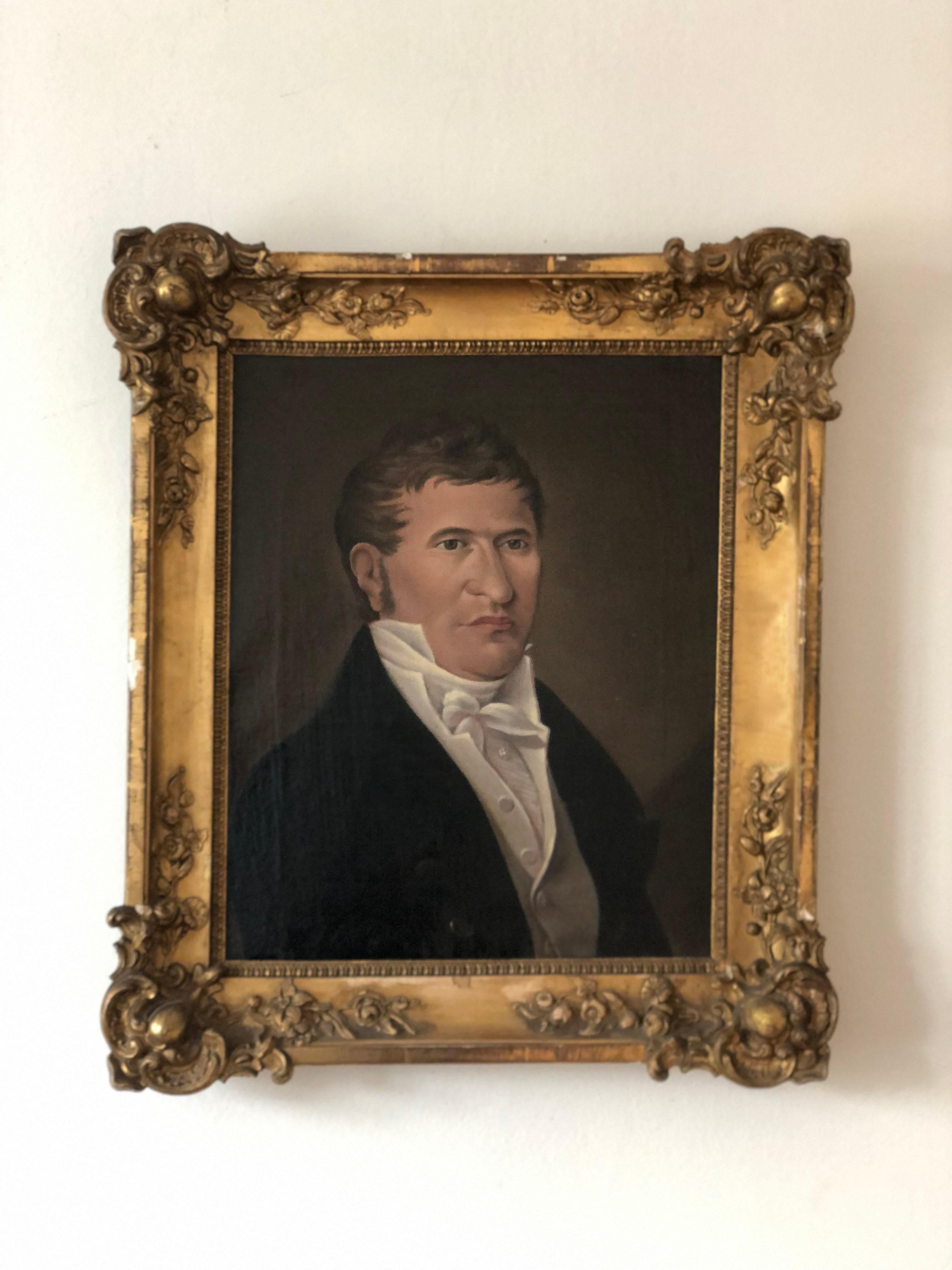 This 19th-century oil painting features a well-dressed German gentleman, likely from the upper class. He is formally dressed in a black jacket with gold buttons, a white high-collared shirt, vest, and a silk tie fastened with a flower-shaped jewel.