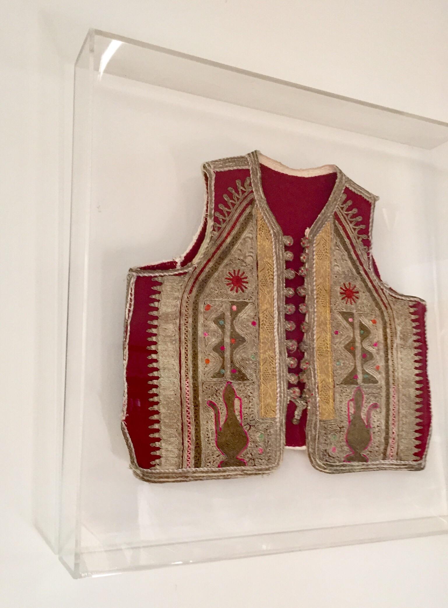 Authentic late 19th century antique ottoman Turkish vest in red velvet decorated with elaborate gold and silver thread, trimmed with gold metallic thread.
Beautifully framed and displayed in a Lucite shadow box
Elegant vest handmade embroidery on