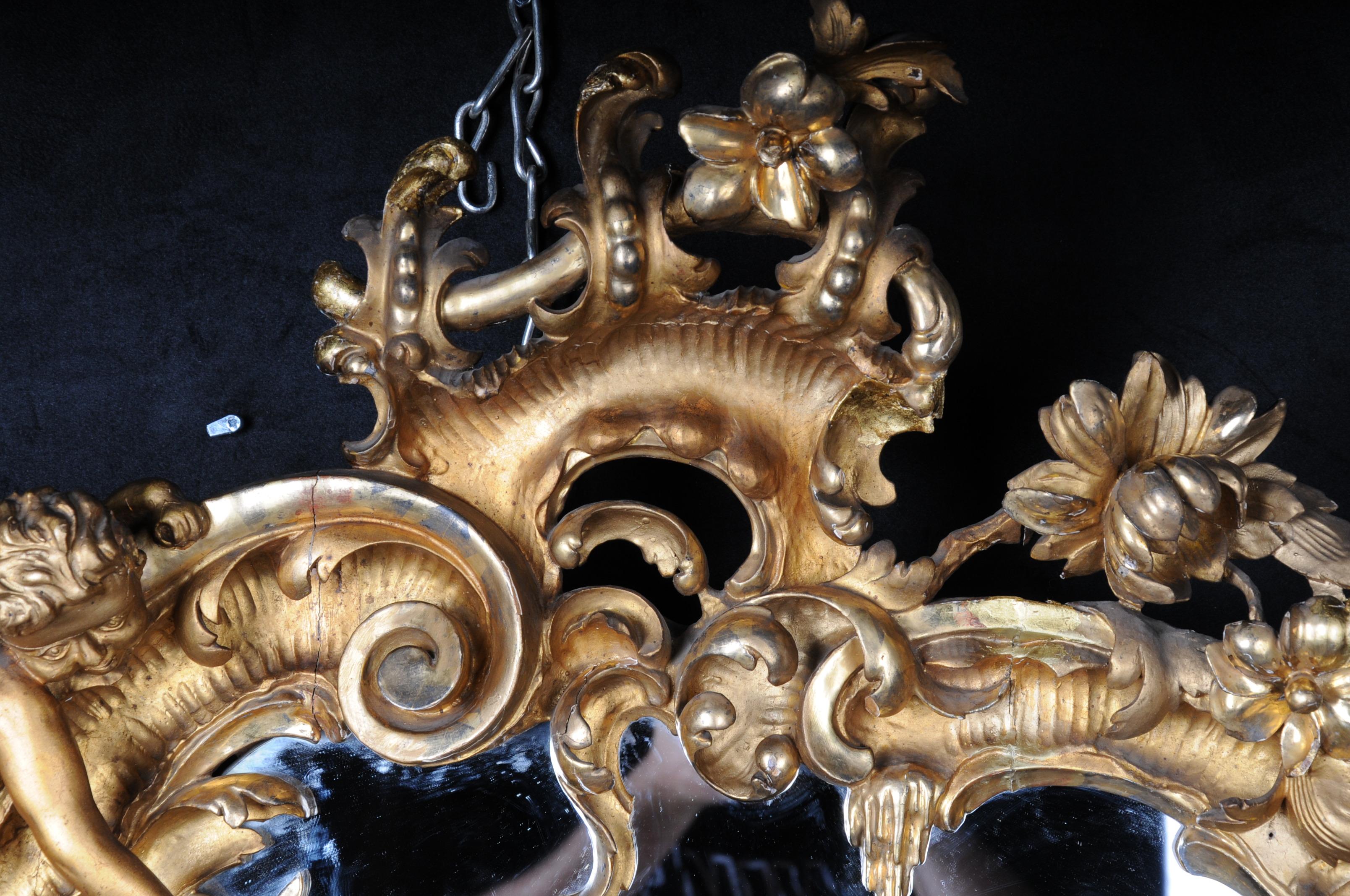 miroir antique rococo du 19ème siècle, doré vers 1880, Napoléon III.
Cadre en bois, sculpté et doré. Cadre de miroir de forme rocaille avec fleurs, putto et tête de putto. Vieux verre de miroir. Travail manuel de très haute qualité

(M-42).