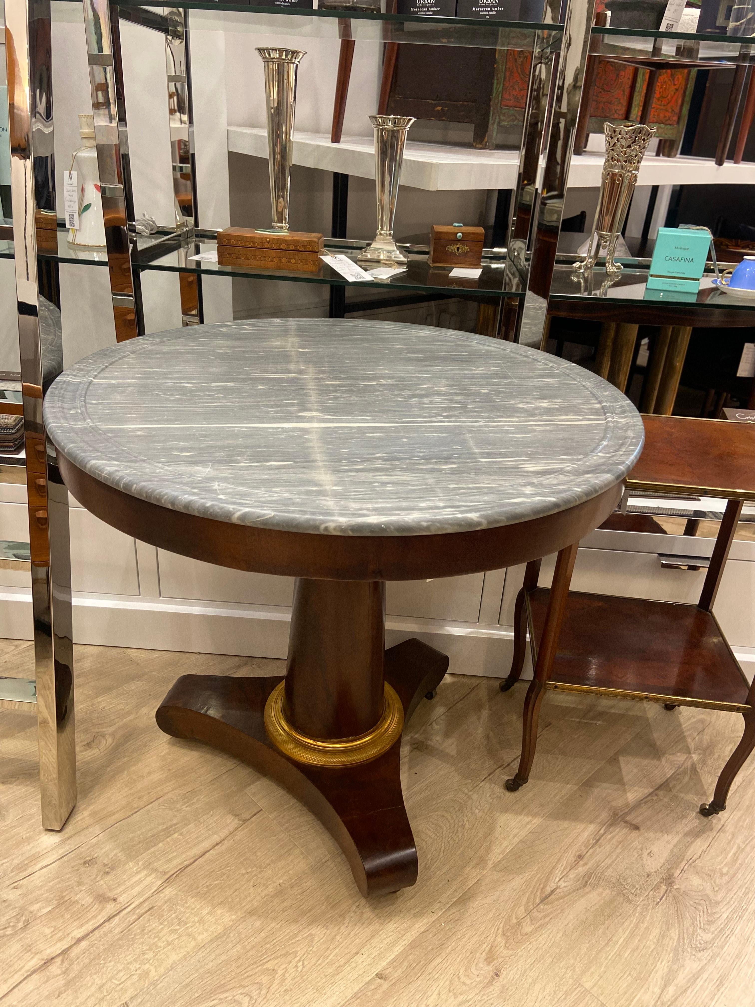 Une table centrale française exceptionnelle du XIXe siècle, offrant un équilibre raffiné de grâce et de grandeur, et un superbe exemple d'artisanat d'époque.

Au cœur de cette pièce élégante se trouve un plateau circulaire en marbre gris aux