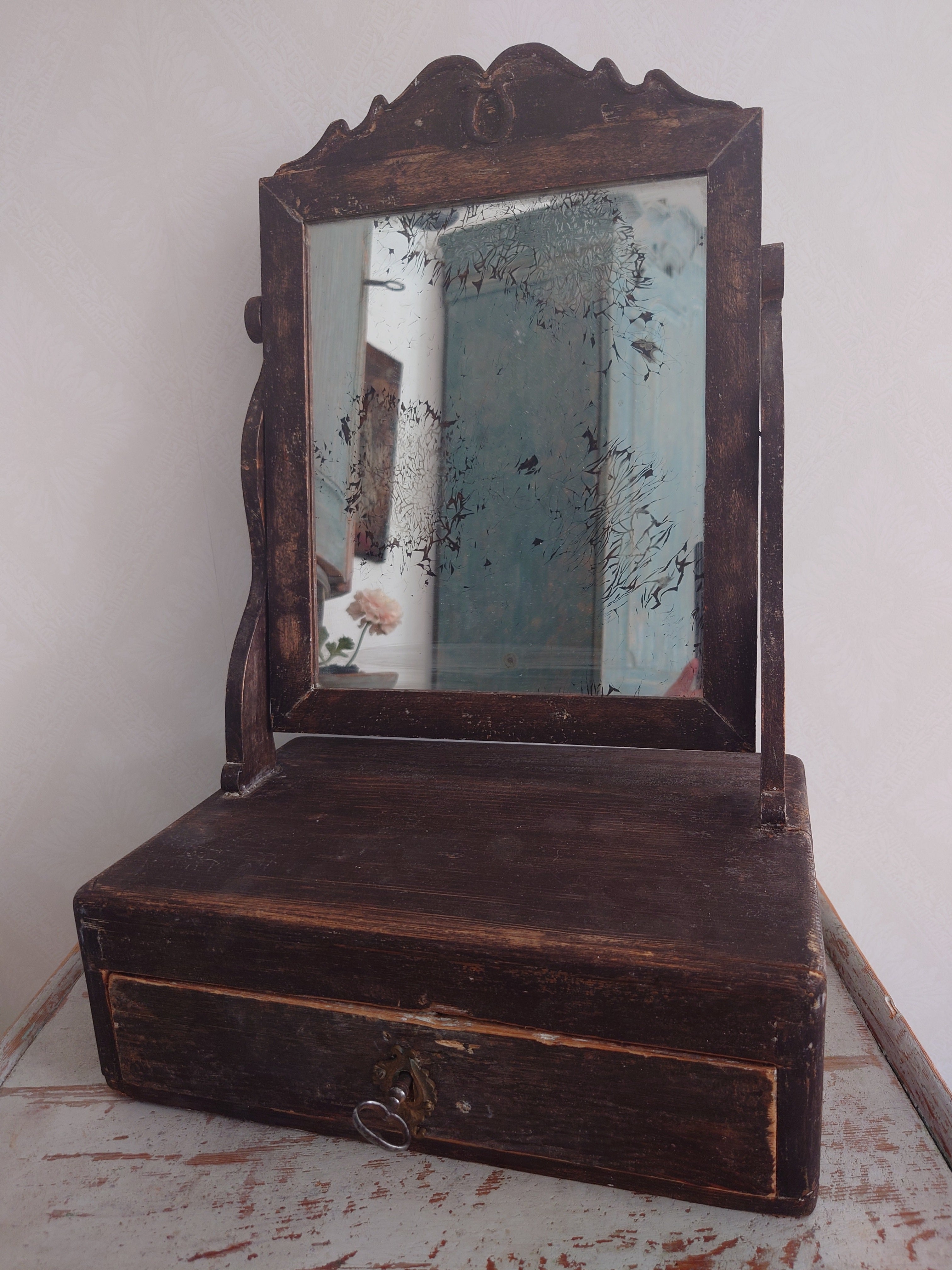 Miroir de courtoisie / miroir de table rustique suédois du 19e siècle, daté de 1870.
Le miroir présente de jolis détails sculptés sur le dessus.
 Cette peinture originale  Le miroir dispose d'un tiroir où l'on peut ranger peigne, brosse ou autres