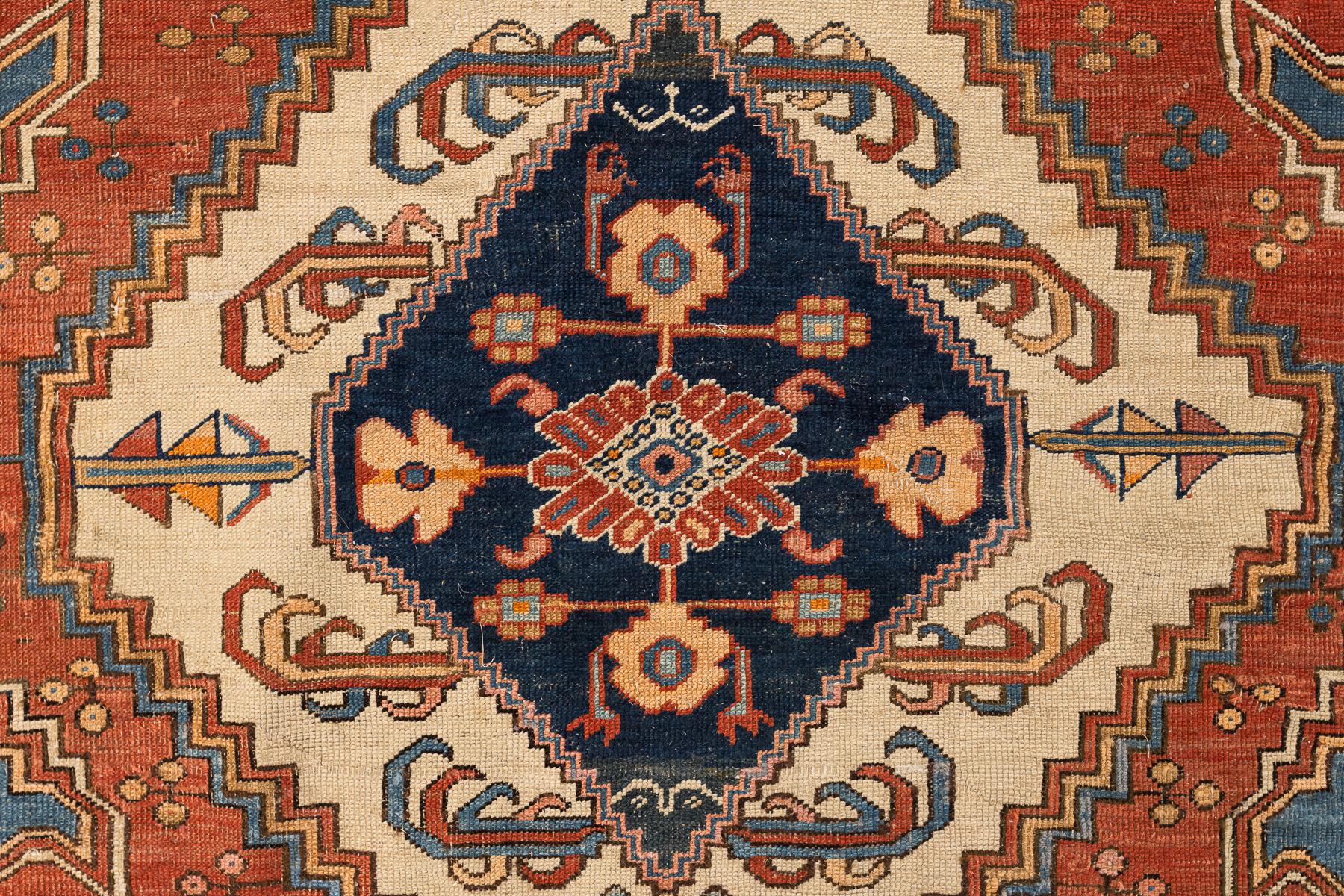 Dieser beeindruckende Serapi-Bakschaisch-Teppich aus dem 19. Jahrhundert zeichnet sich durch seine kühne grafische Präsenz und die harmonische Farbpalette aus Ziegelrot, sanften Blautönen und warmem Elfenbein aus. Sein langgestrecktes