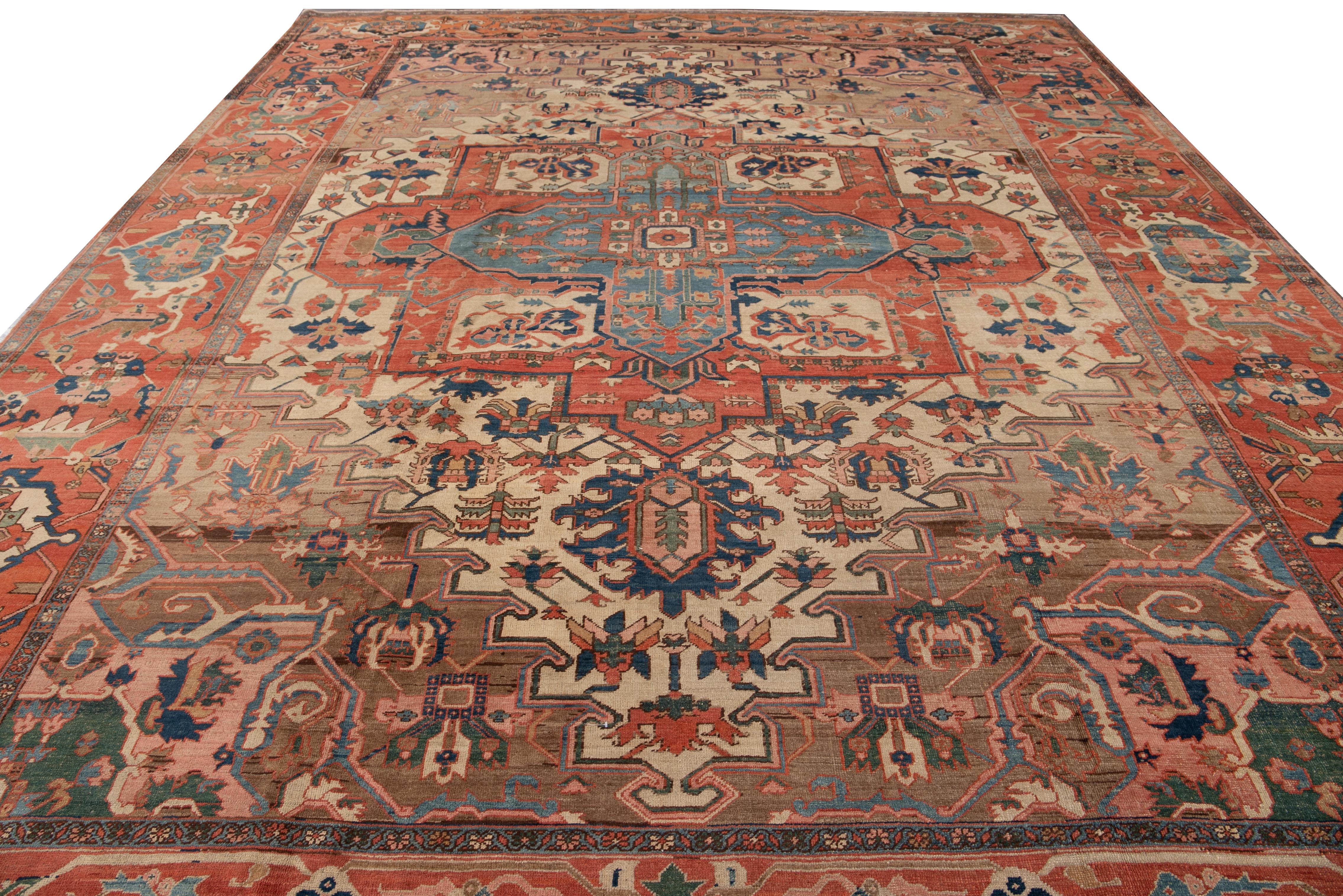 Stunning one-of-a-kind antique Serapi rug, hand-knotted from wool, featuring a beige and brown field. This Serapi rug is framed with terracotta color and embellished with multi-color accents, showcasing a floral design in the center medallion.

This