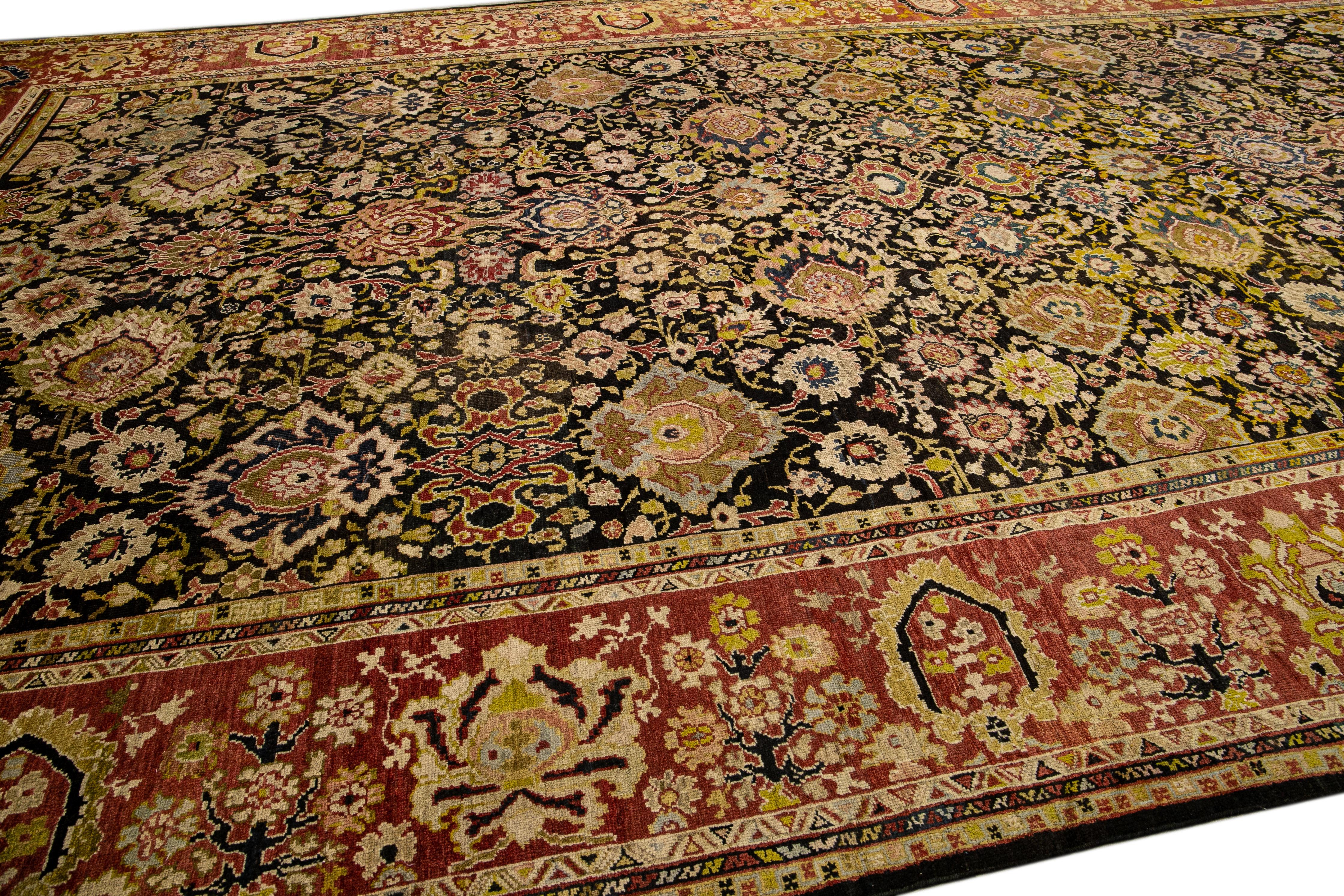 Beautiful Sultanabad hand-knotted wool rug with a black field. This antique piece has a rusted frame and multicolor accents in an all-over palmette floral design.

This rug measures: 12'9