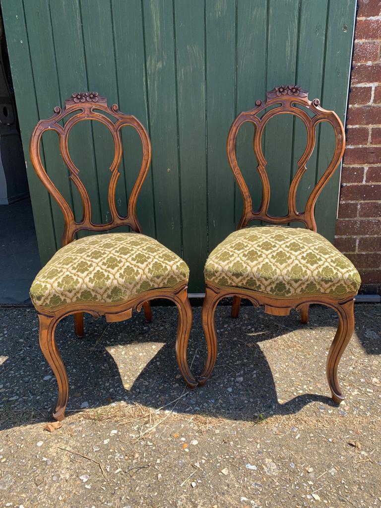 Unusual pair of antique Swedish Rococo Biedermeier carved dining chairs with top grade mahogany quilted veneers in a deep mid oak color with lovely detail to the carving with Classic Rococo fluted legs.

The sprung seats will  ship in the original