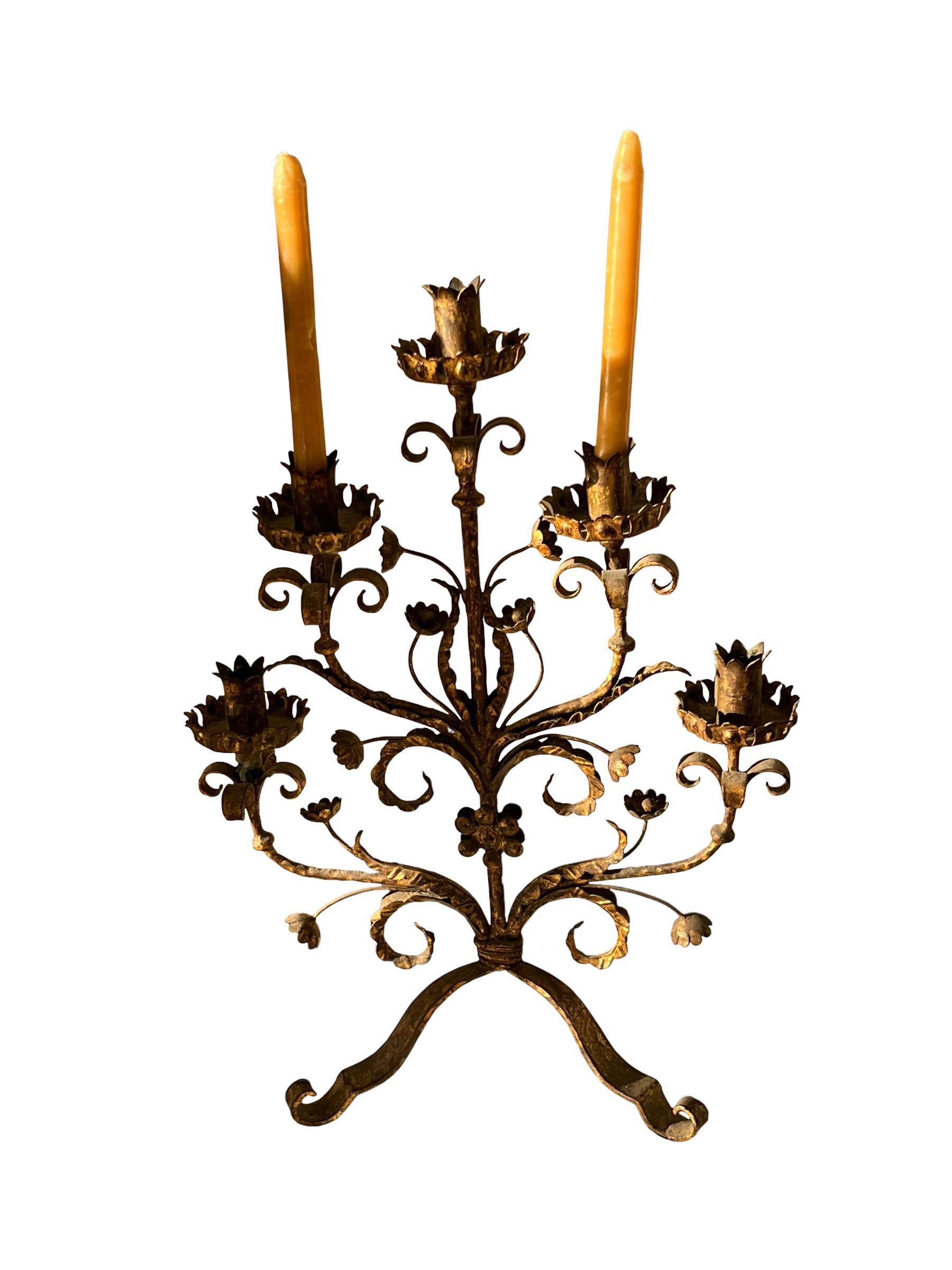 A wonderful large 19th century five arm tole candelabra. Candelabra stands on three legs with a whimsical floral motif throughout.