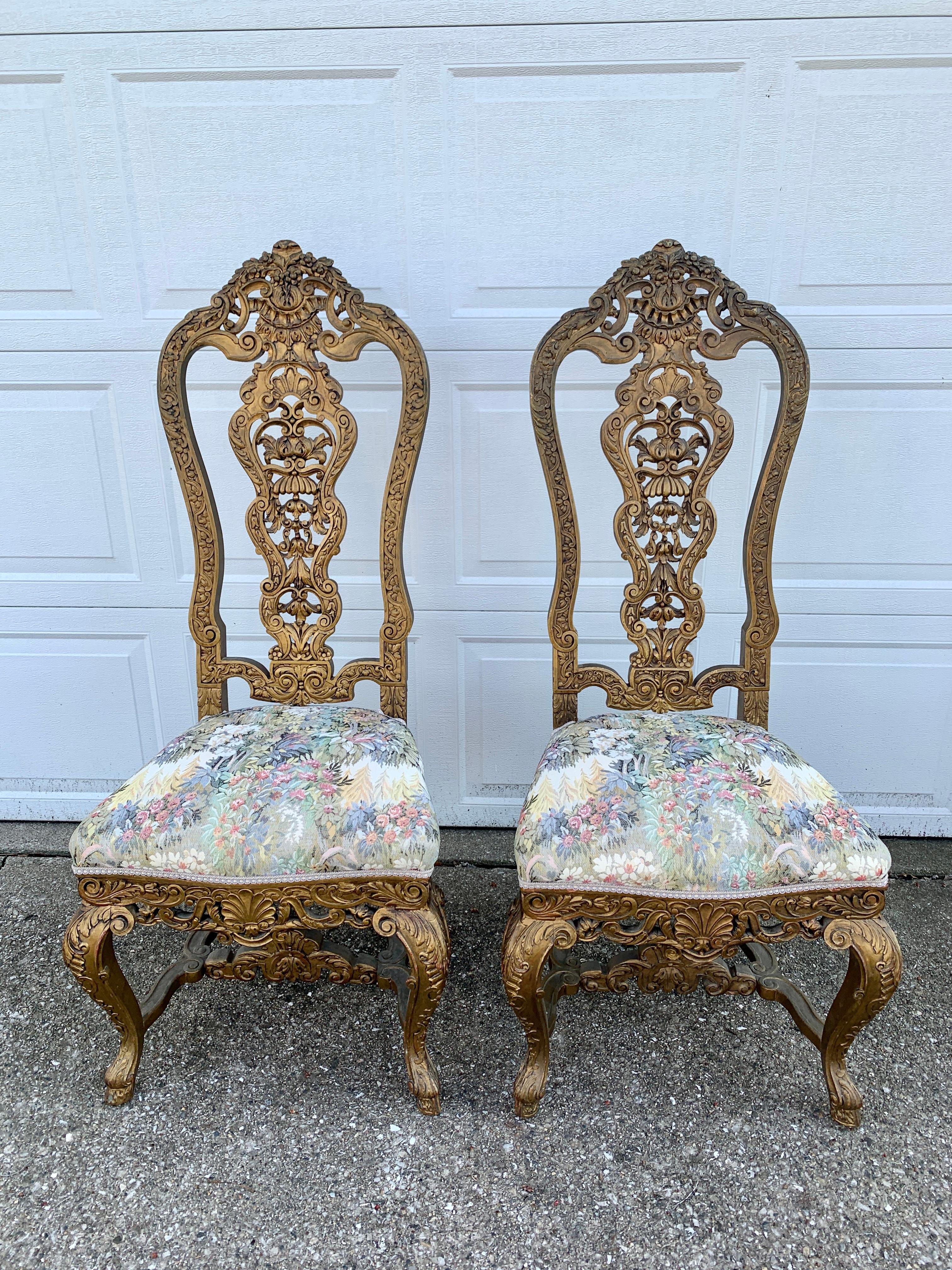 A stunning pair of antique Venetian throne or court chairs with carved shells, foliate details, and cloven hoof feet

Italy, late 19th century

Carved giltwood frames with tapestry upholstery

Measures: 22.25
