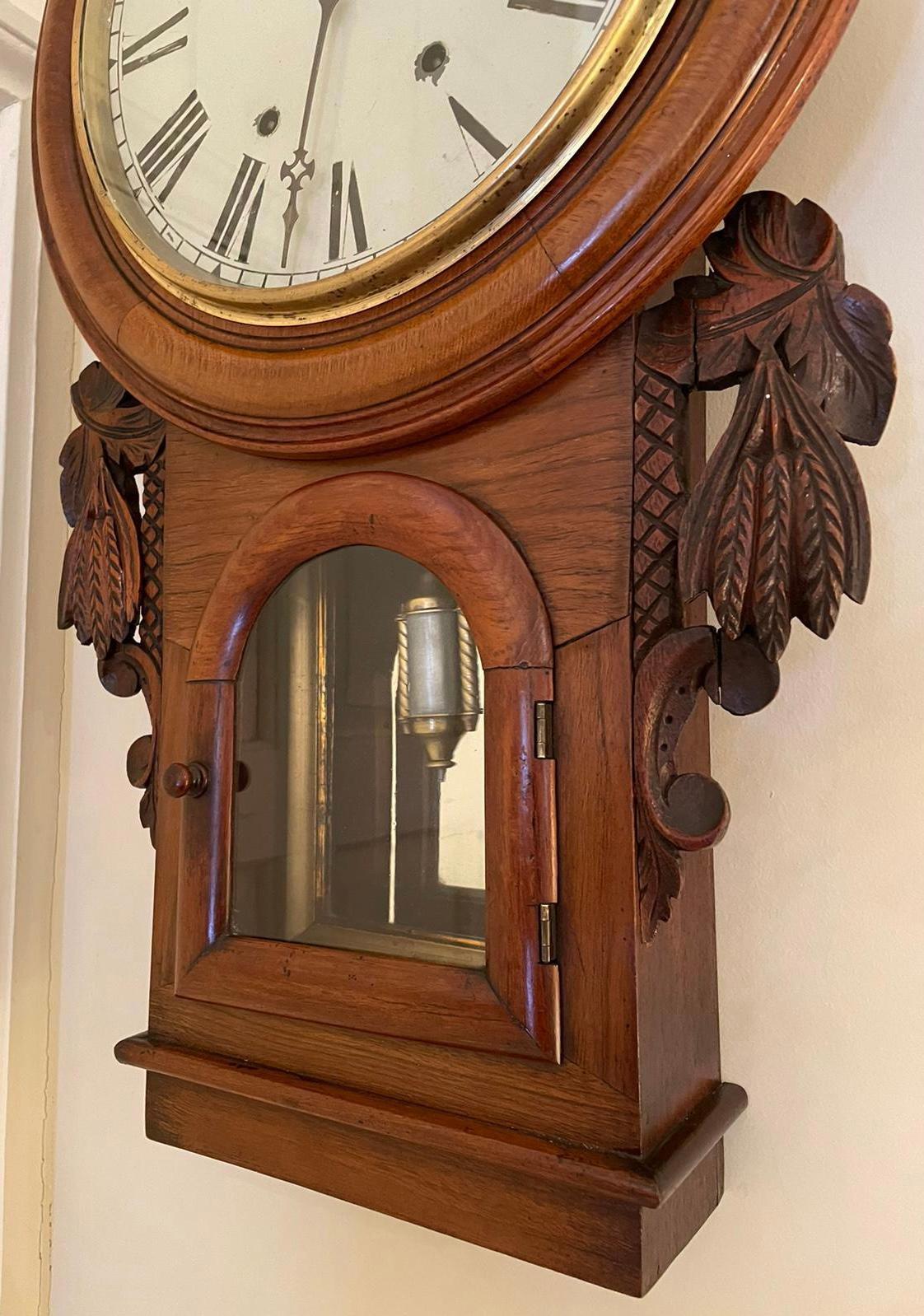 
19th century antique Victorian carved walnut eight day wall clock having an attractive circular painted dial with original hands and original brass bevel and glass. The walnut case is charming with a small arched glazed door to the short trunk
