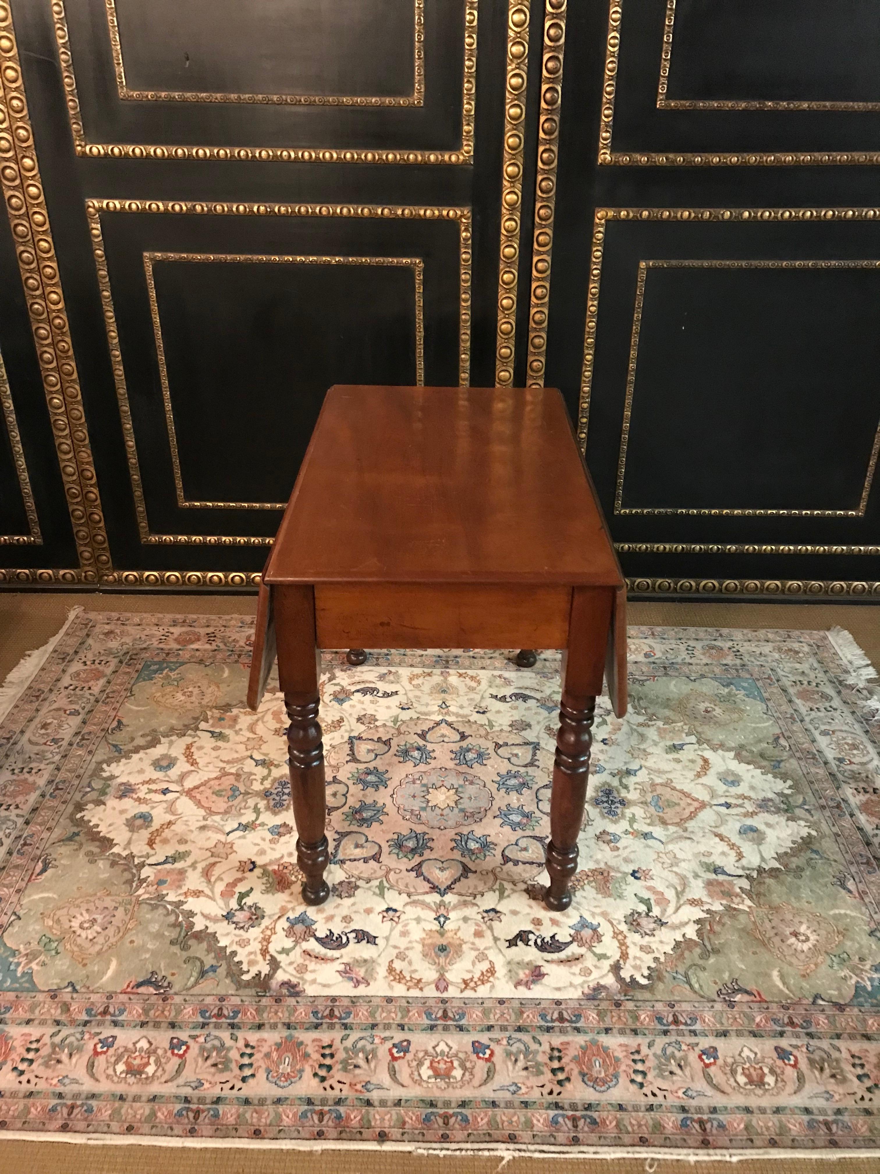 Solid mahogany. Straight frame base on balustrade-shaped legs. Deep drawer on the side. Slightly protruding table top, foldable on both sides.

Excellent warm patina grown over decades. Age-related use traces.
Originates from a Berlin estate.