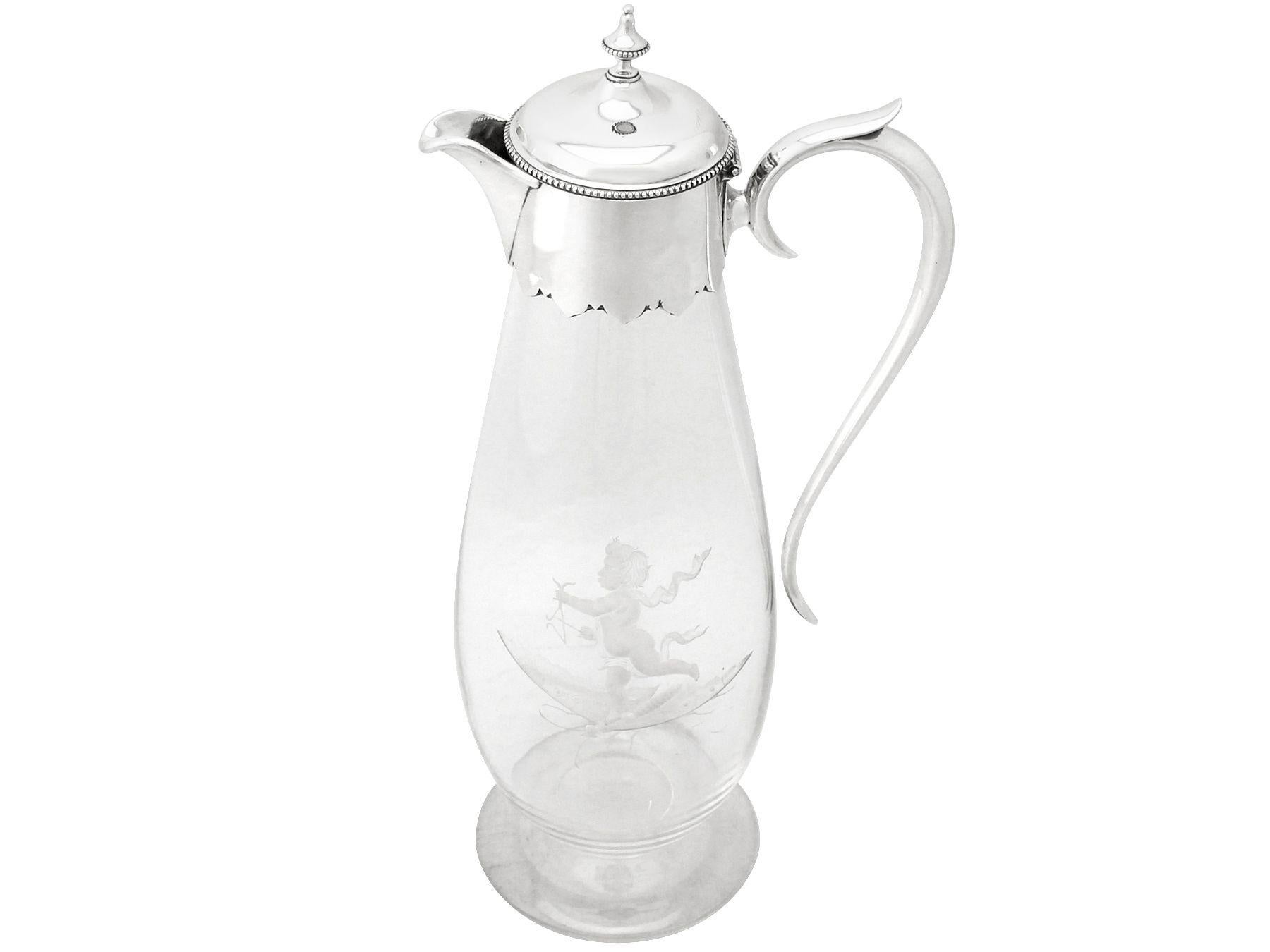 An exceptional, fine and impressive antique Victorian glass and silver mounted claret jug; part of our silver mounted glass collection.

This exceptional antique Victorian glass and sterling silver and glass claret jug has a circular rounded form