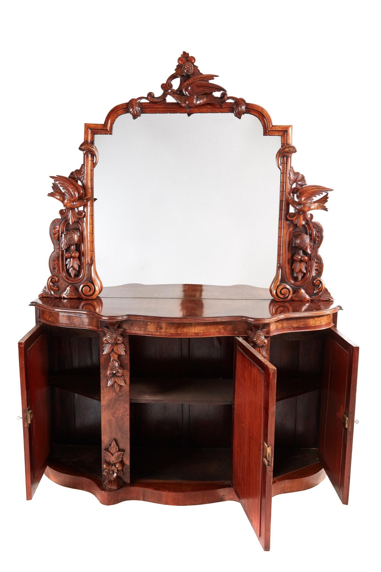 An outstanding 19th century Victorian antique carved mirrored walnut credenza with a magnificent carved solid walnut mirror back and spectacular carvings and moulded edges. The serpentine shaped base has a delightful burr walnut top thumb moulded