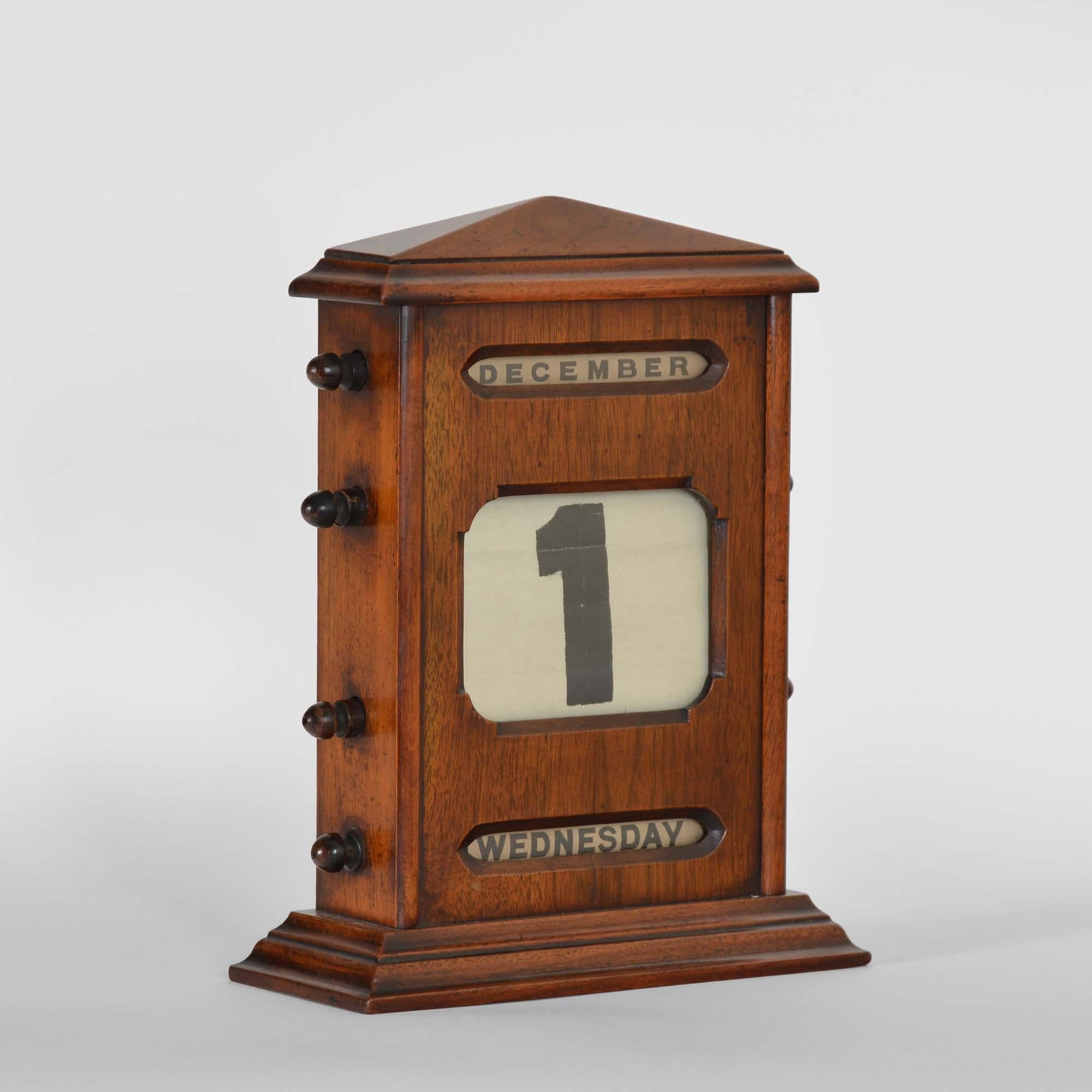 Grand calendrier perpétuel en noyer
Le coffret en noyer est doté d'un fronton et d'un socle. Entièrement réglable pour le jour, la date et le mois, il suffit de tourner les poignées sur le côté du calendrier pour changer le jour/date/mois.  Les