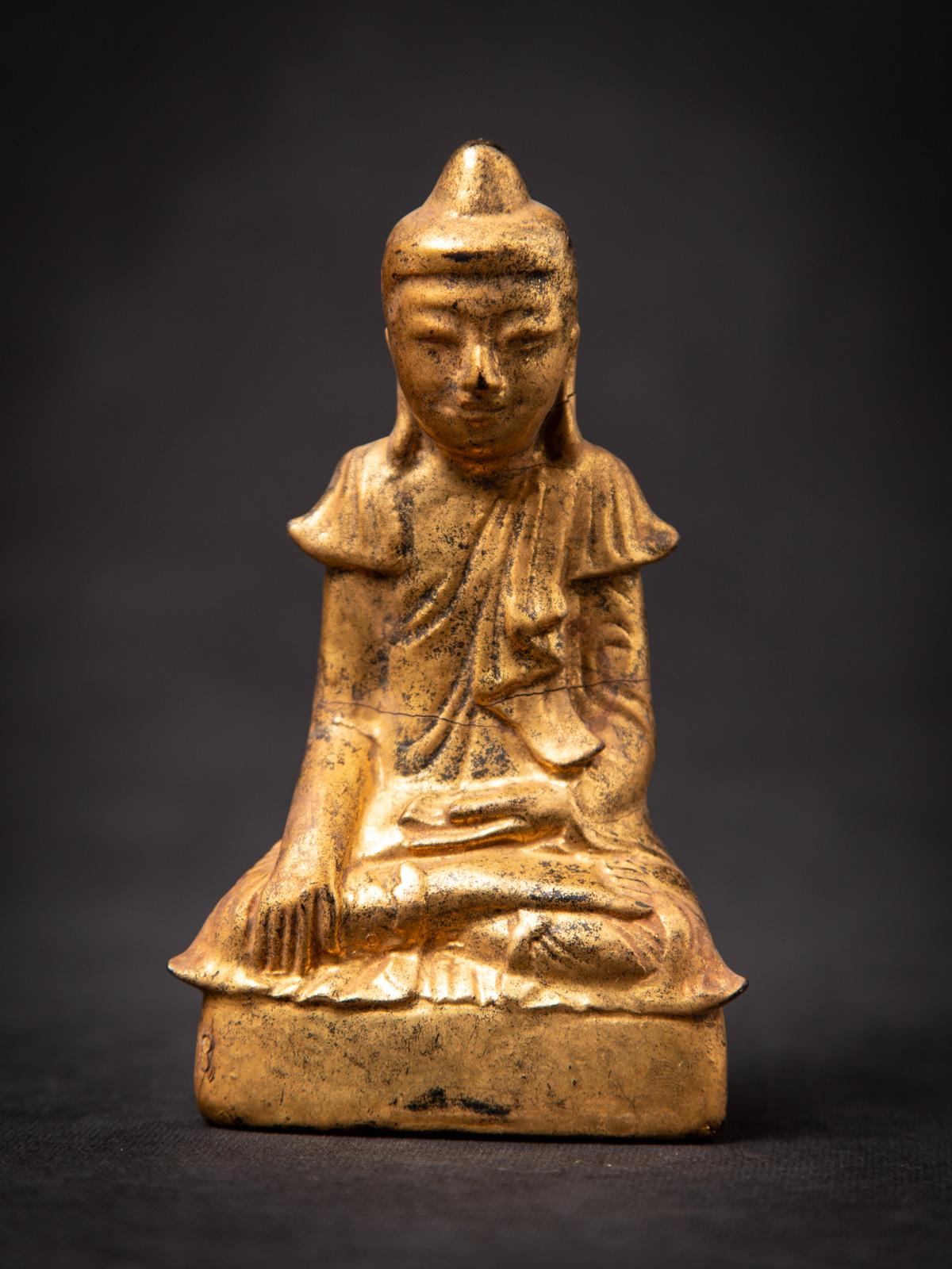 Presenting this antique wooden Burmese Buddha statue, an authentic 19th-century piece showcasing the refined Shan (Tai Yai) style. Expertly carved from wood and gilded with 24 karat gold, it features the iconic Bhumisparsha mudra, symbolizing the