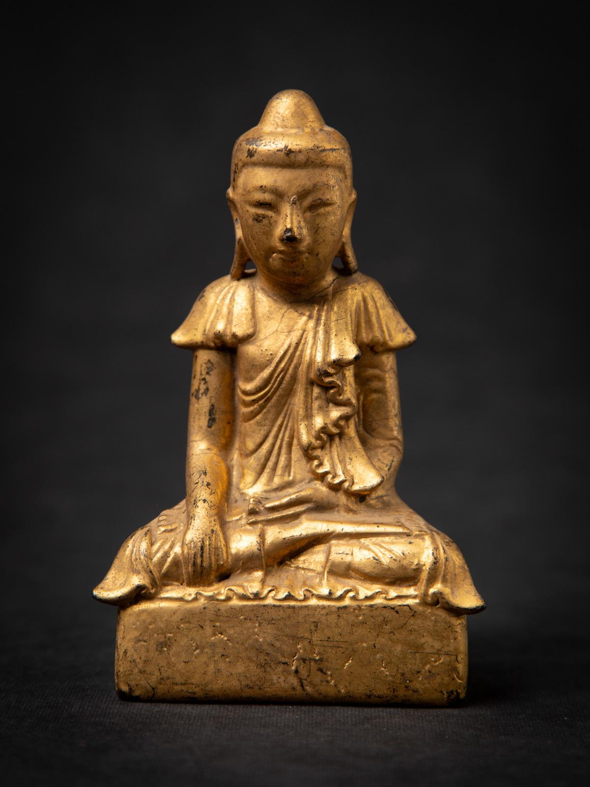 Esta antigua estatua de Buda birmana de madera es un delicado ejemplo de la artesanía de estilo Mandalay del siglo XIX. Tallada en madera y bellamente dorada con oro de 24 quilates, mide 13,8 cm de alto, 8,8 cm de ancho y 4,3 cm de profundidad, y