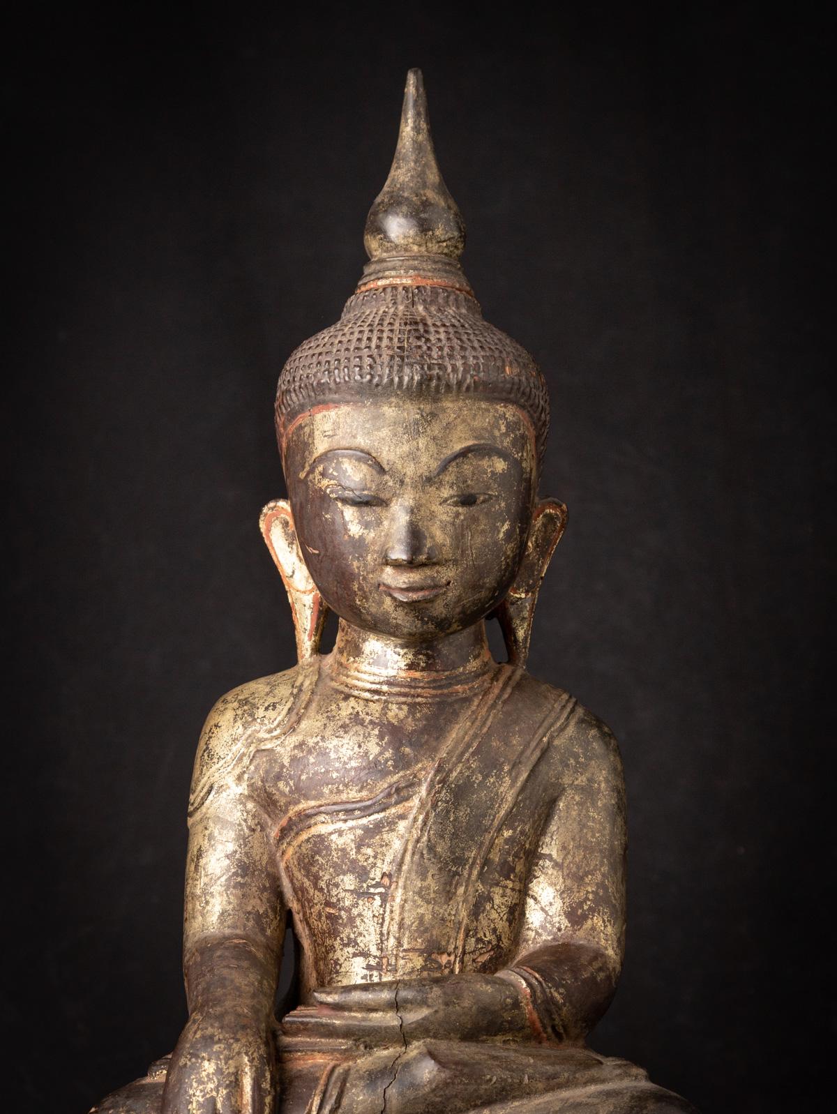This Antique wooden Burmese Buddha statue is a remarkable piece of art and spirituality. Crafted from wood, it stands at a height of 68,5 cm, with dimensions of 21 cm in width and 28 cm in depth. The statue is adorned with the radiant beauty of
