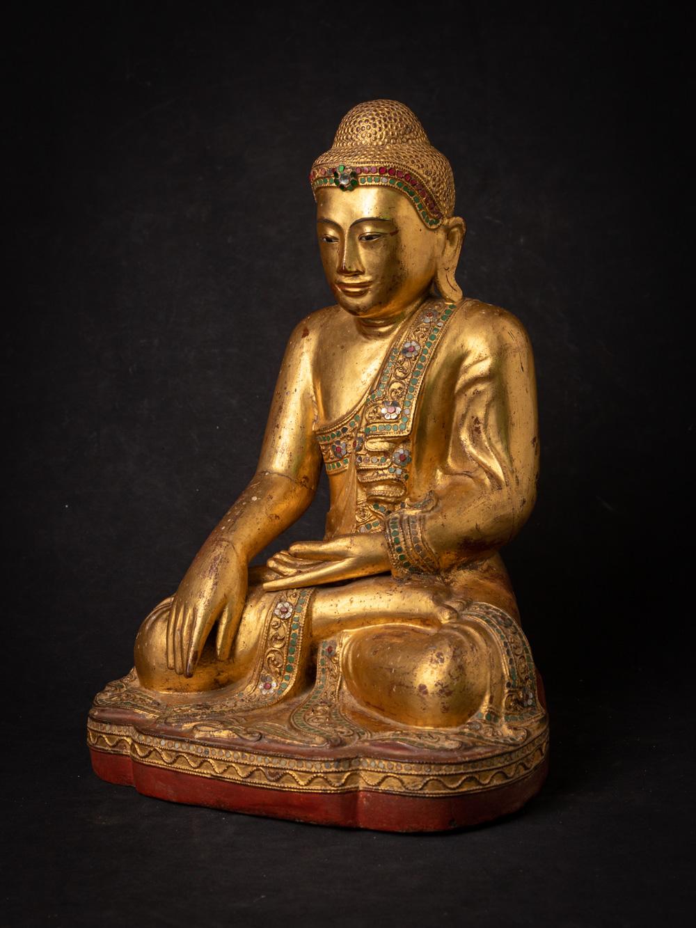 The antique wooden Burmese Mandalay Buddha is a truly exquisite and spiritually significant artifact originating from Burma. Crafted from wood and adorned with 24-karat gold gilding, this Buddha statue stands at 38.4 cm in height and measures 28.2