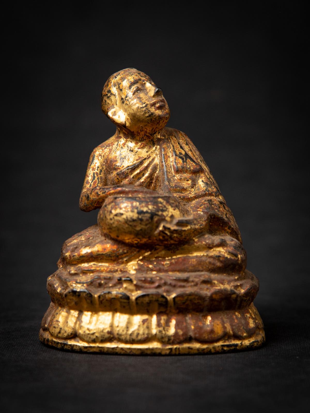 Wir präsentieren diese antike birmanische Mönchsstatue aus Holz, ein authentisches Stück aus dem 19. Jahrhundert, das das reiche spirituelle Erbe Birmas widerspiegelt. Fachmännisch aus Holz geschnitzt und mit 24-karätigem Gold vergoldet, zeigt er