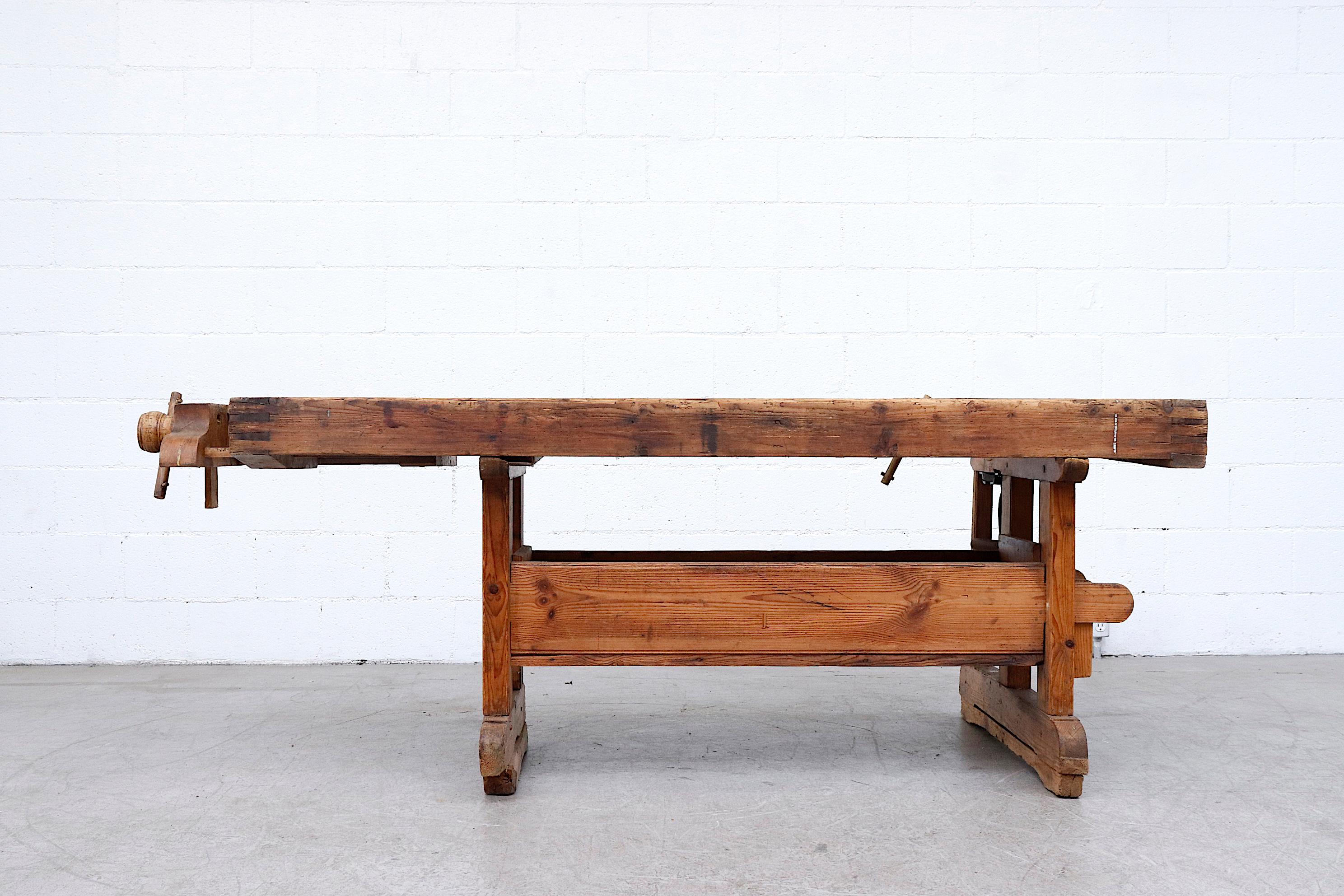 Amazing extra large natural wood work bench with lower storage and visible wear. In very original condition with working wood cranks and original removable hand drill. Incredible craftsmanship and functionality in overall impressive shape.