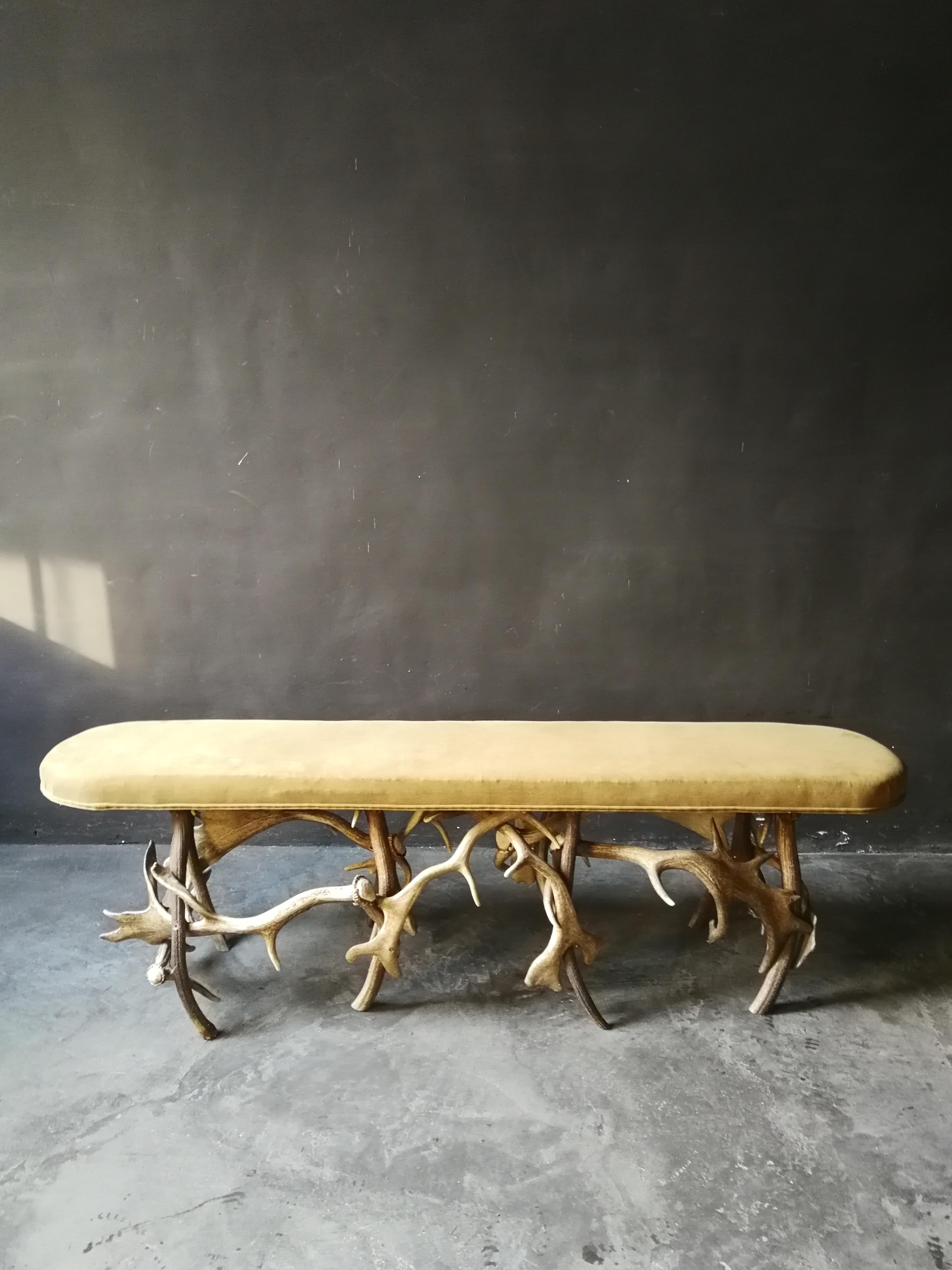 This very decorative bench rests on antlers composition. The fabric is a solid cotton and has a dark camel color. This bench fits very well in an entrance hall, or as a wall ornament in an office or library.
 