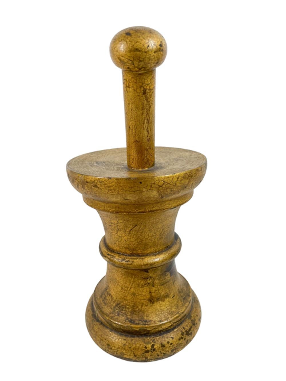 Apothecary trade sign or sale stimulator in the form of a mortar and pestle in gilt wood. The mortar of cylindrical waisted form with a central half round band and stepped rings at top and bottom, the solid top with the handle of a pestle rising at