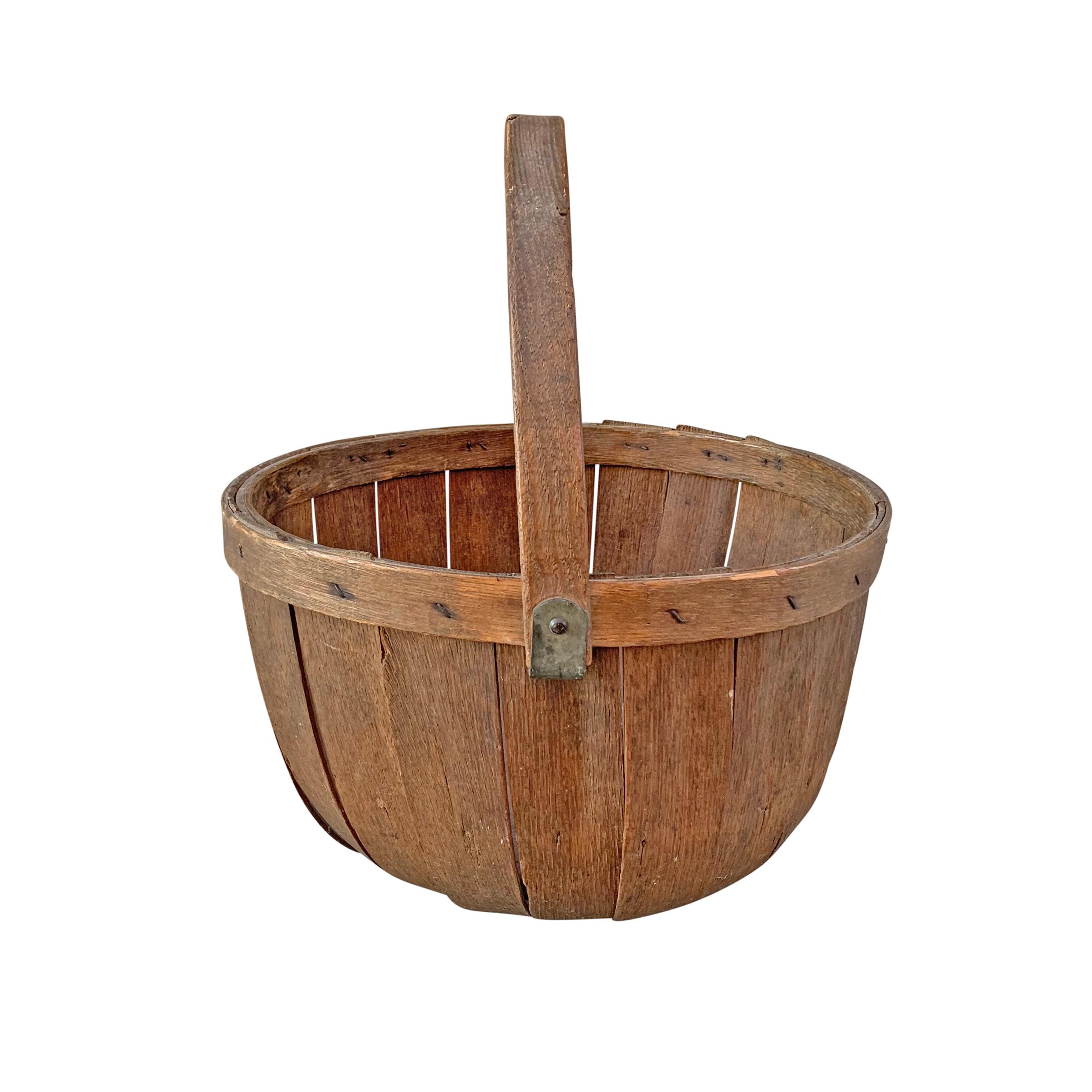 A sweet 19th century American oak splint apple bushel basket with an adjustable handle and a beautiful oxidized finish. Perfect in your kitchen or for use as a waste paper basket in a powder room.