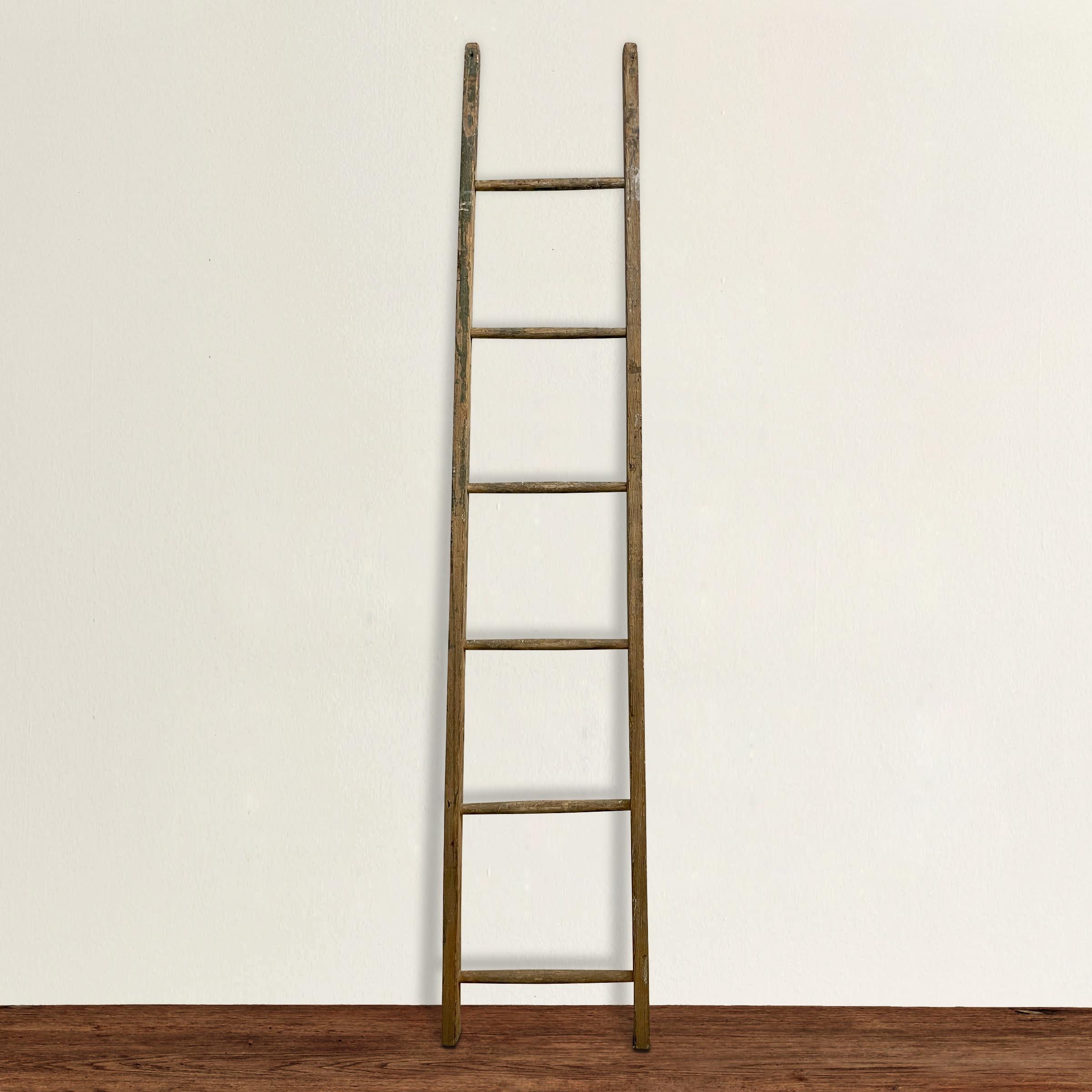 A quaint 19th century American ladder used for picking apples and with traces its lovely old painted finish. Perfect for hanging towels in a bathroom, or blankets in the living room. Found in Michigan.