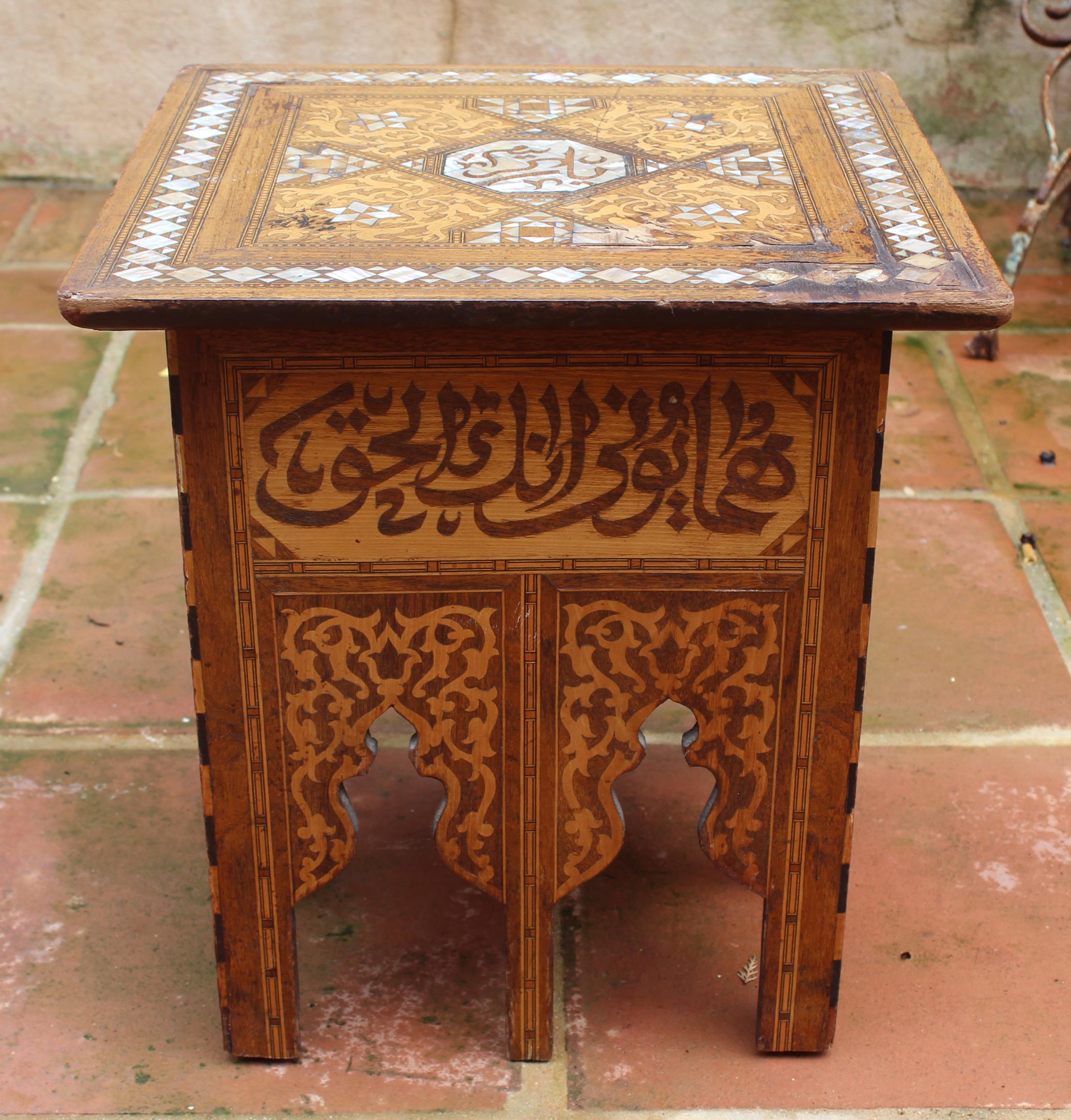 19th century Arabic coffee table richly decorated with mother of pearl inlay on the top, Geometric and Arabic writing inlay motifs with different woods on the side panels, ending in Islamic cut-out arches.

 