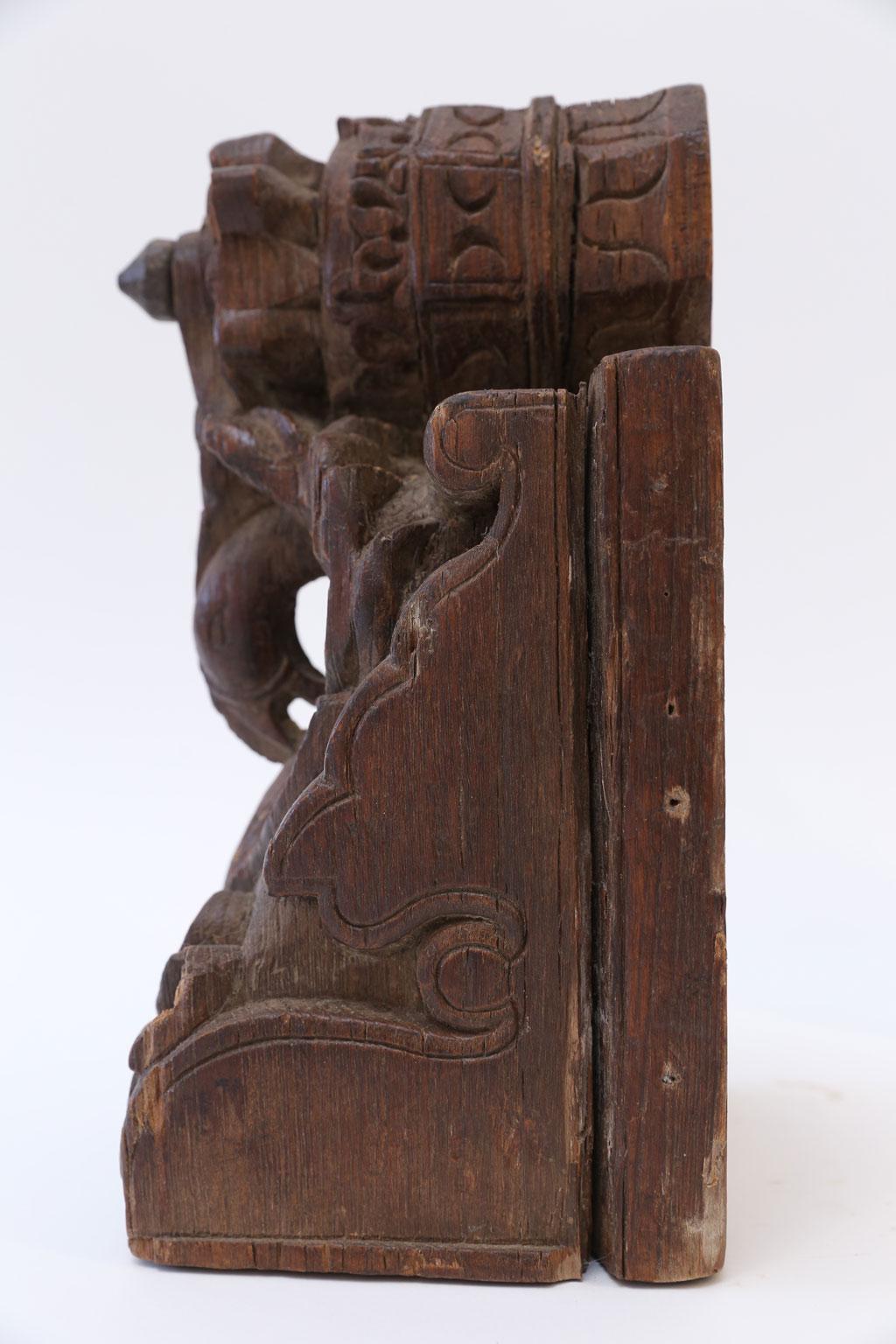 Dark brown carved wood architectural fragment dating to 19th century, India. Perfectly sized to be a decorative accessory for shelves or a desk top.
 