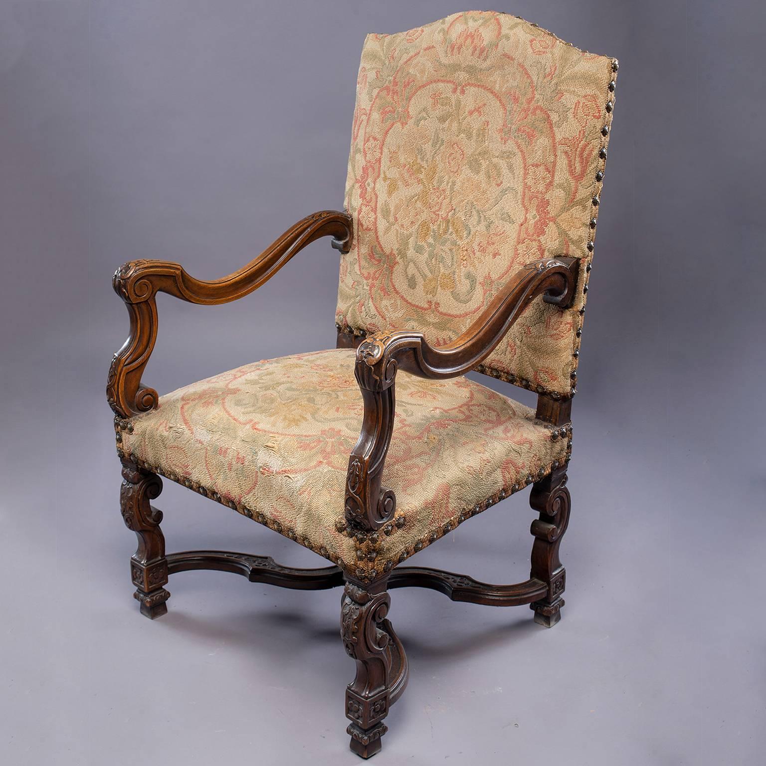 French armchair has an oversized carved dark wood frame with X-form stretchers, original tapestry upholstery and brass nailhead trim, circa 1880s.
Arm height: 28.5”
Seat height: 19”
Seat depth: 20”.