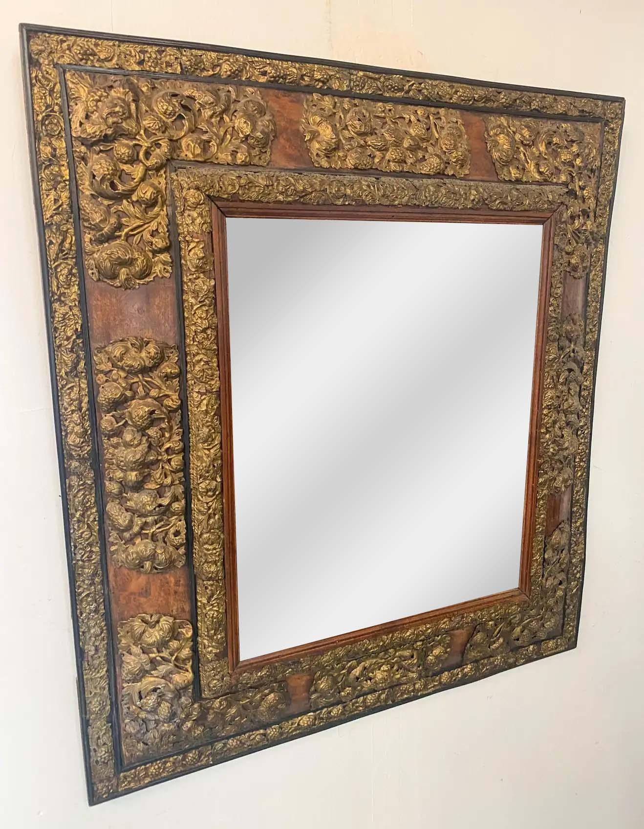 A beautiful antique 19th century Art Nouveau mirror. The mirror features intricate floral design made of foil in gold embellishing the thick three dimensional wooden frame. The mirror is elegant and will be the center piece of any wall or