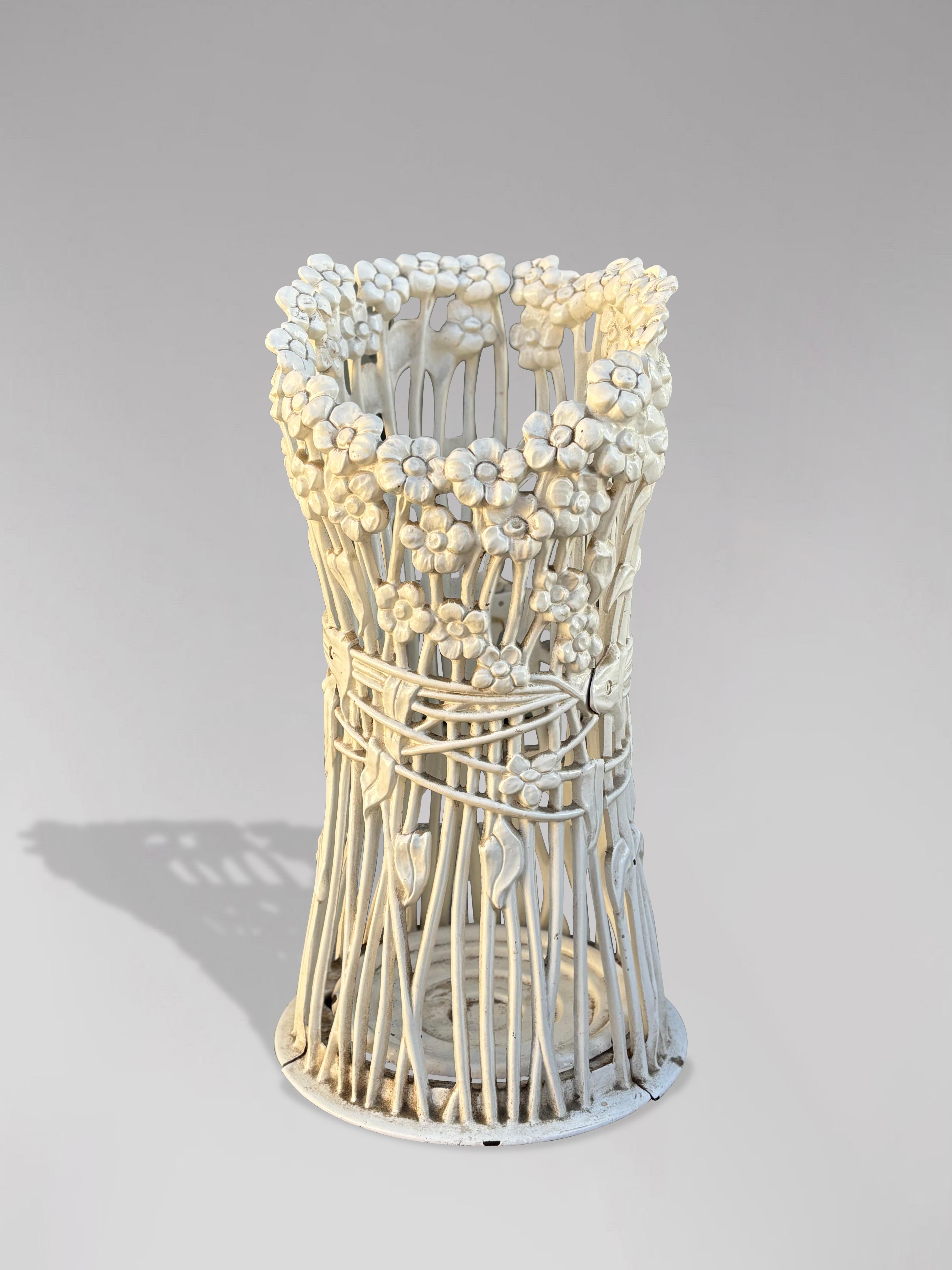 This late nineteenth-century Art Nouveau period cast iron umbrella stand or stick stand, dating to around 1890, features an ornate floral display. This antique umbrella stand showcases an appealing white painted circular frame with intricate floral