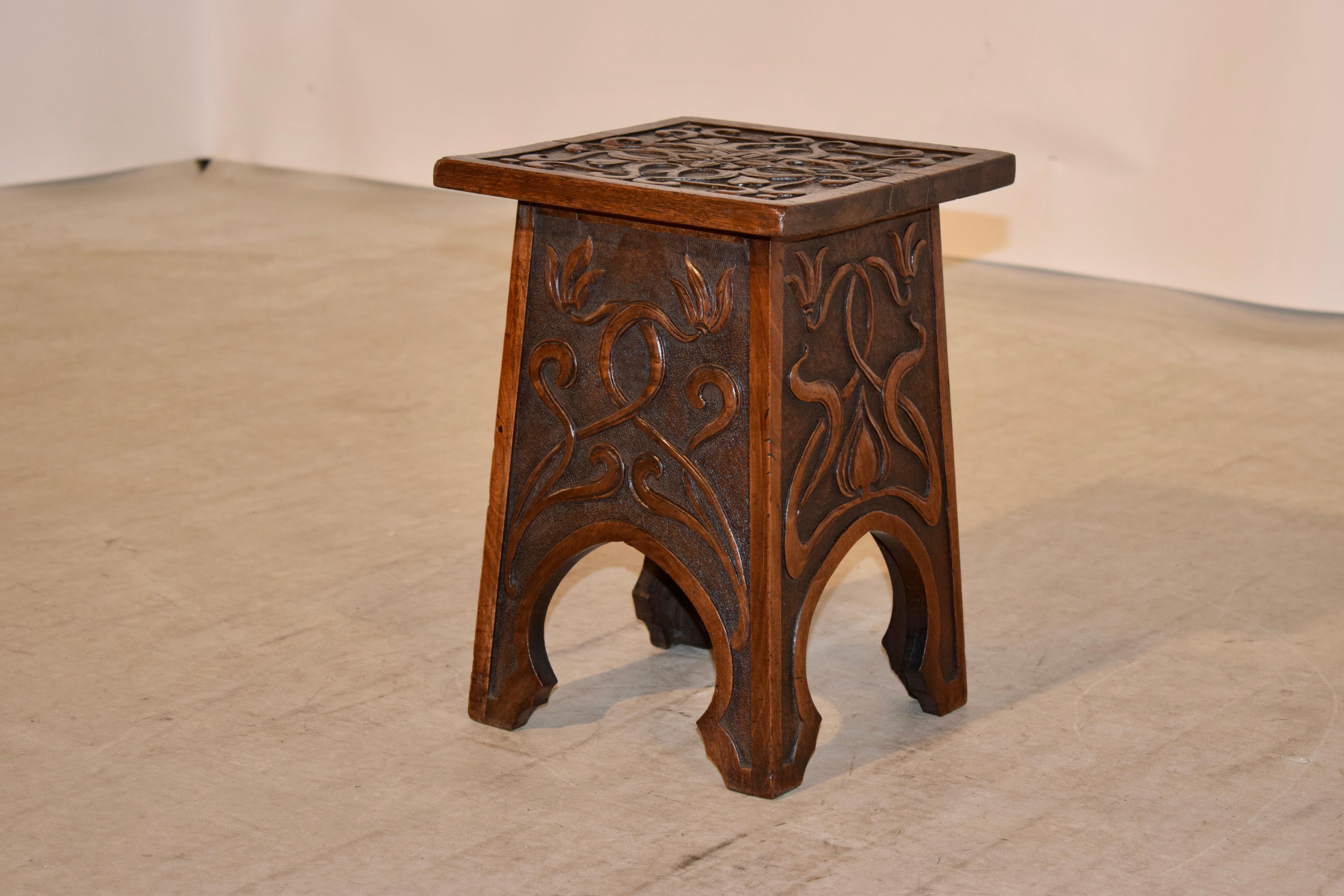 19th century oak stool from France with wonderfully hand carved Art Nouveau decoration. The top is banded and has gorgeous decoration in the central panel, following down to four decorated sides with banding and oval cutouts which form the feet.