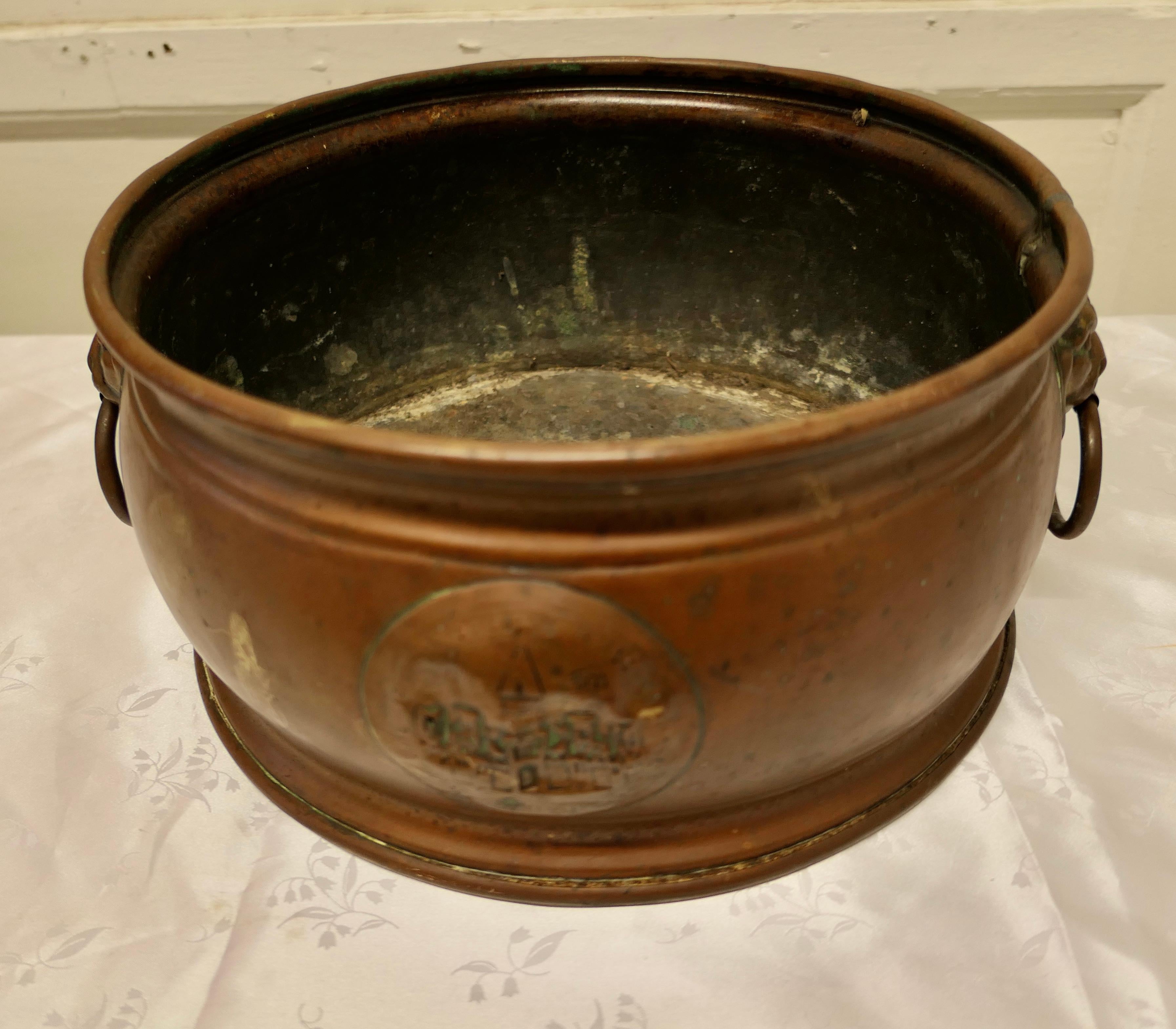 19th Century Arts and Crafts brass planter

This is a good quality brass piece, it is hand beaten, the brass has a very dark patina, it almost looks like copper, it has lions mask ring handles and a cartouche to the front showing the outline of a