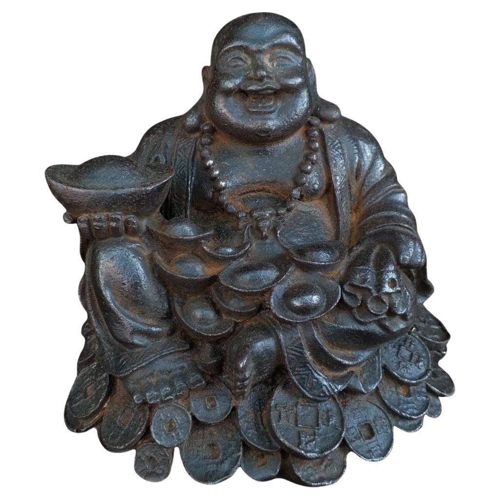 Buda sonriente de hierro asiático del siglo XIX sentado sobre monedas portando oros