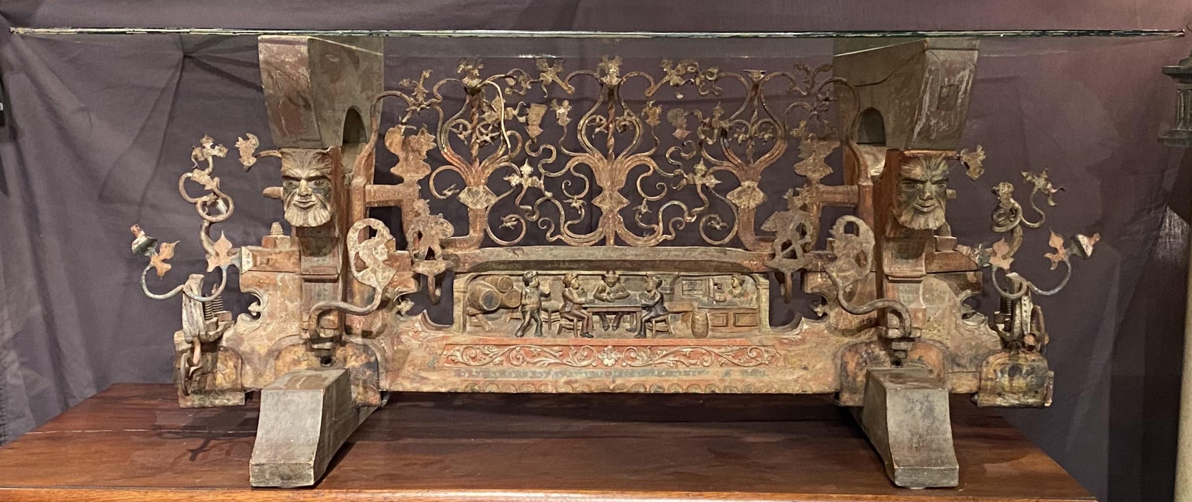 This interesting and super cool low table or coffee table is constructed from 19th century Asian architectural metal and wooden elements, with polychrome figural scenes, carved and gilt scrollwork, and wrought iron geometric forms. The existing