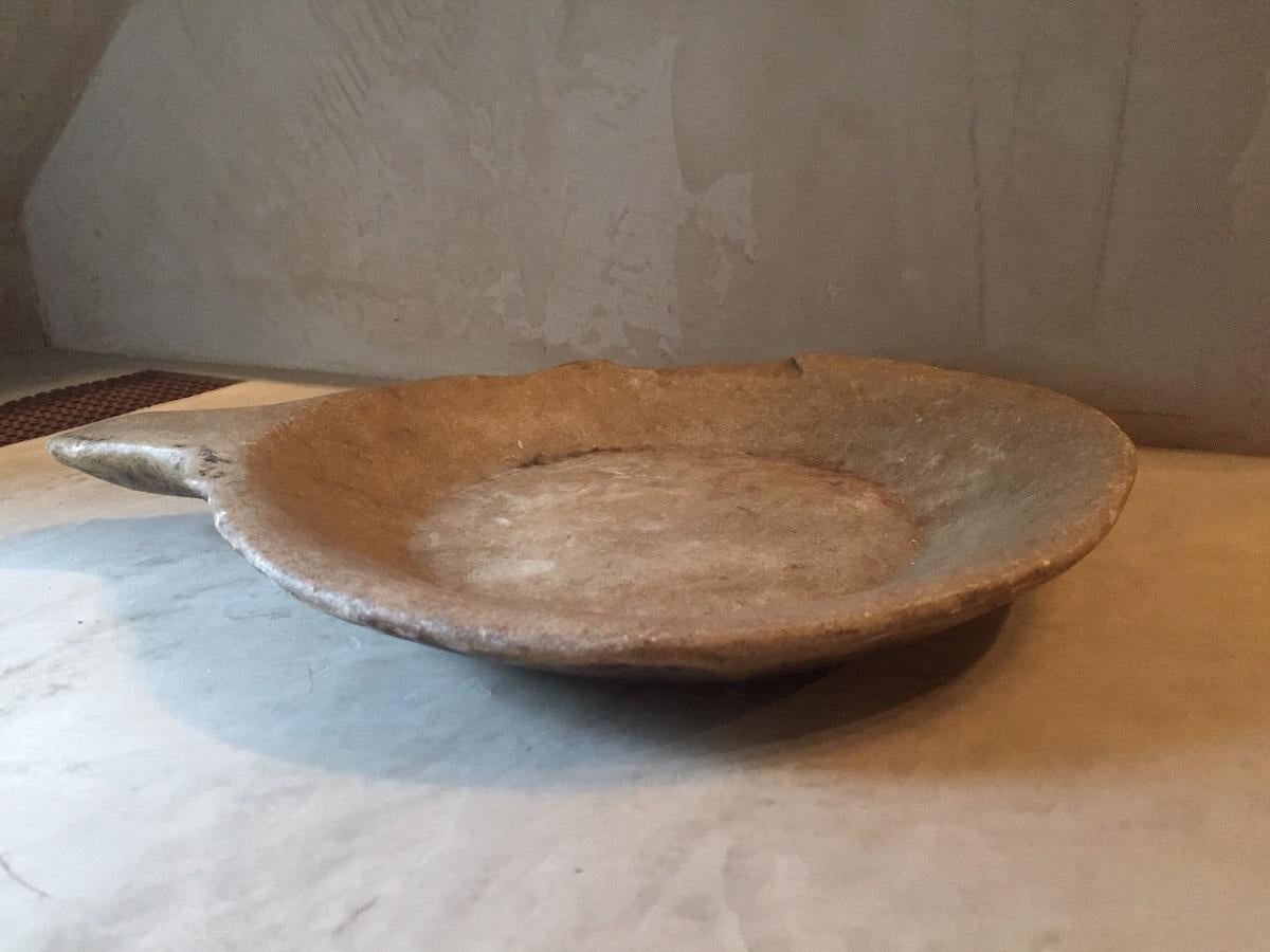A large Asian stone dish with one handle. The stone probably marble but verry much like alabaster. Dishes like this were used for utilitary purposes like presenting and cooking food but also found in religious contexts. Simular examples have been