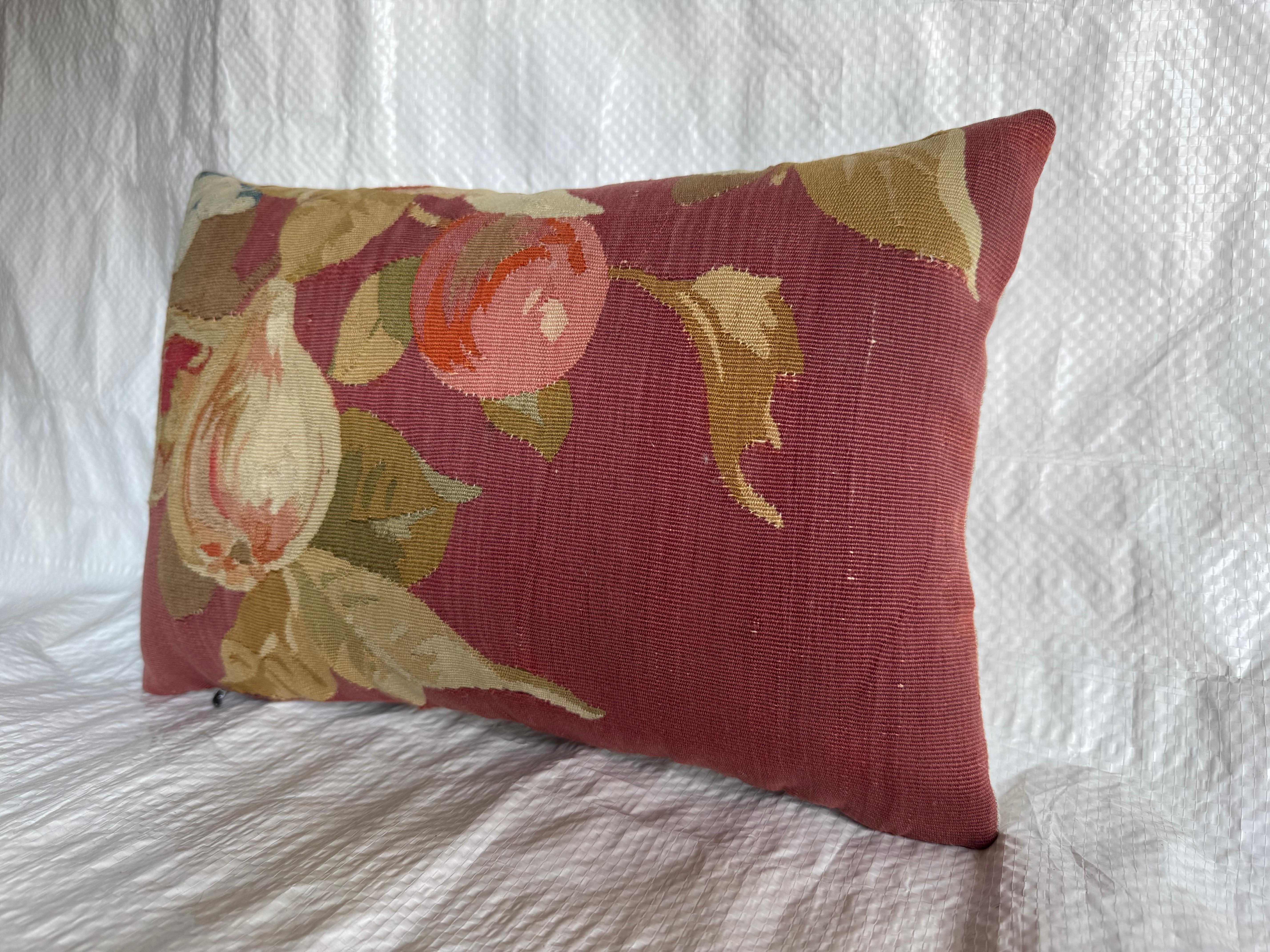 Un élégant coussin en tapisserie d'Aubusson, tissé à la main en France vers 1850. Cette pièce présente un motif fruitier audacieux avec des figues et des pêches parmi le feuillage, tissé dans des tons doux de crème, de rose et de vert sur un riche