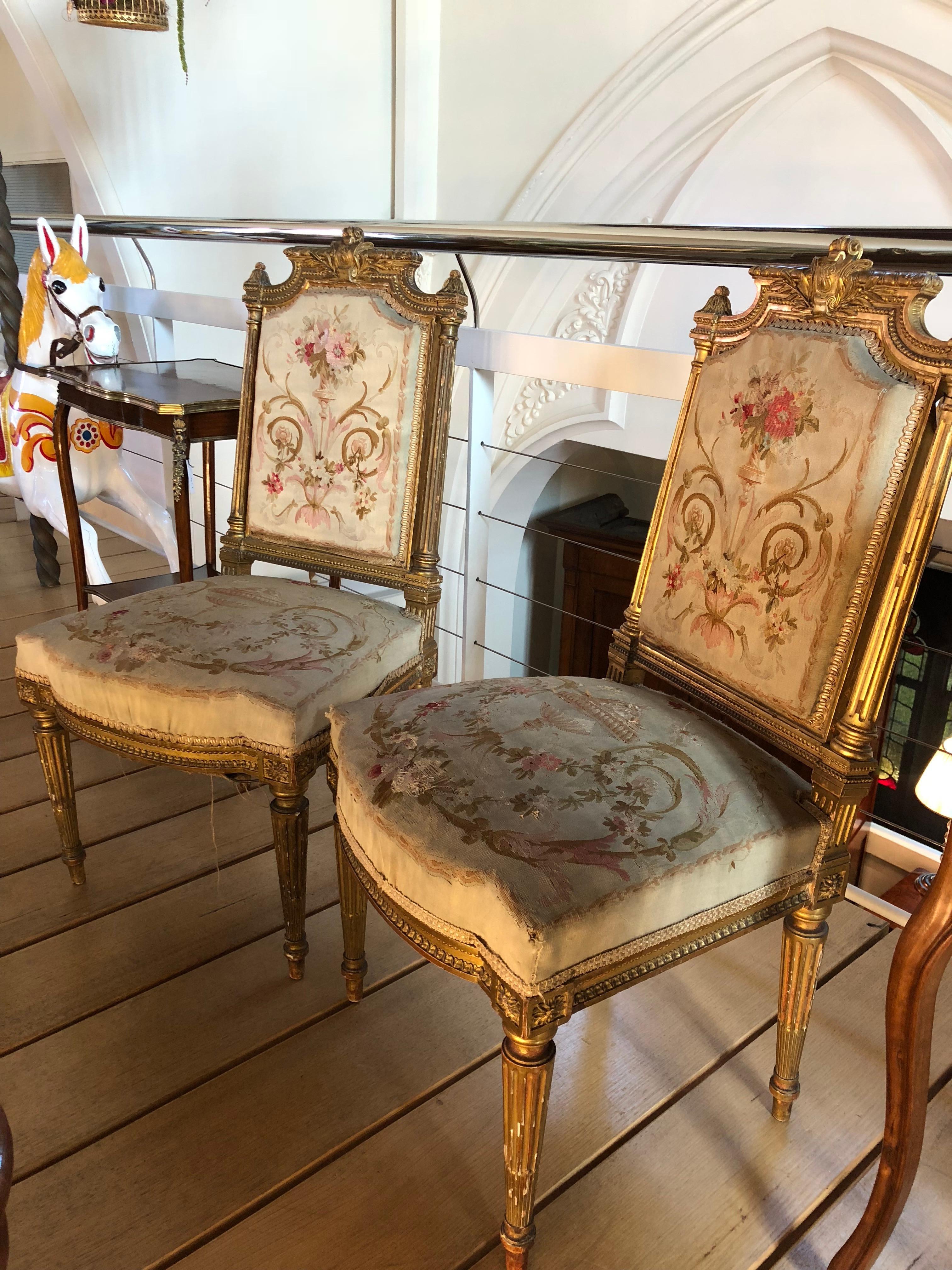 This rare pair of 19th century Aubusson giltwood French chairs feature exquisite original tapestry upholstery, in impeccable antique condition. The iconic Aubusson 'verdure,' scenery on the tapestries feature scrolled fleur and vigne designs, rather