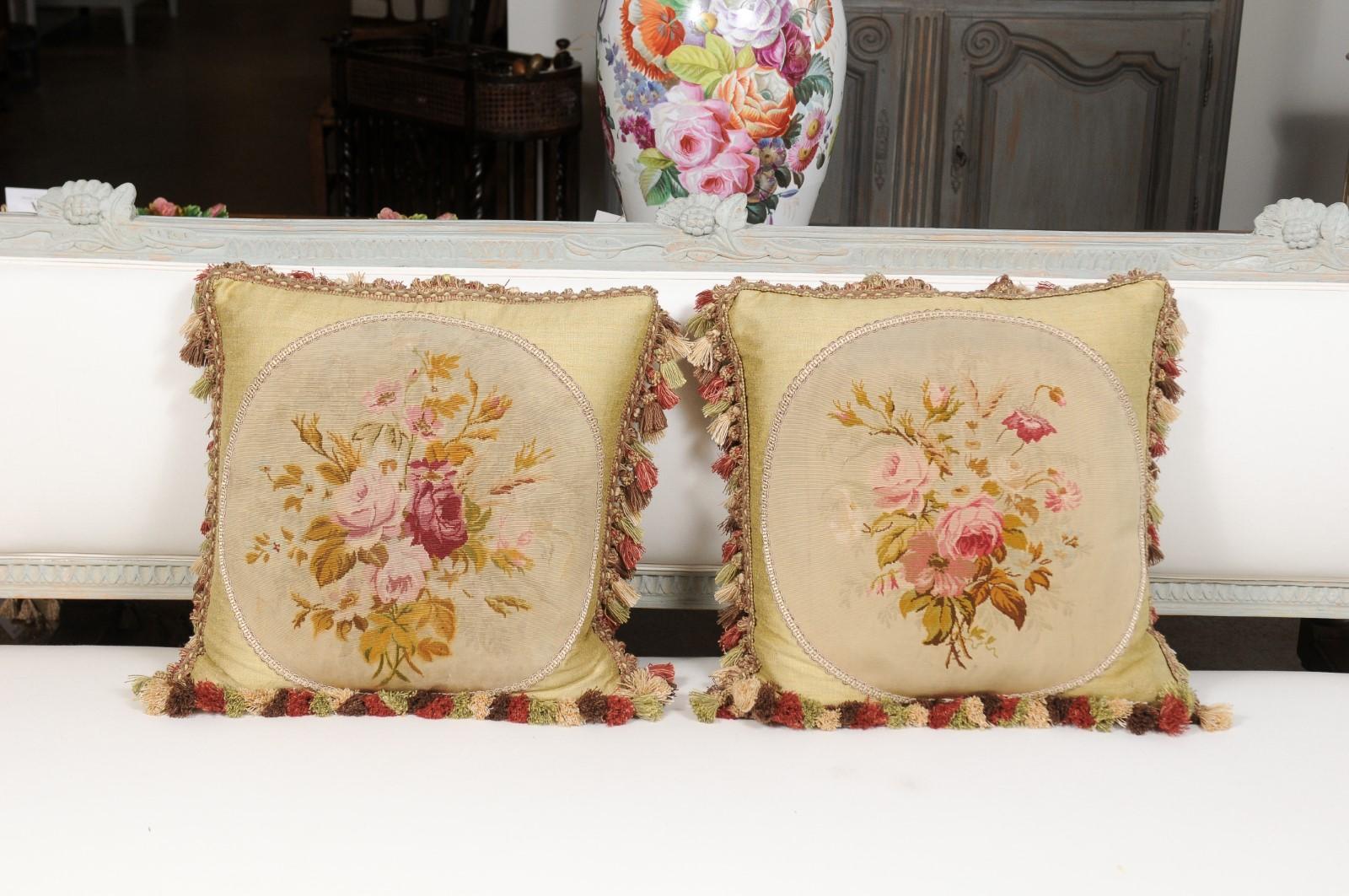 Two French Aubusson tapestry pillows from the 19th century, with floral décor and tassels, priced and sold separately. Born in central France during the 19th century, each of these pillows is made of a delicate Aubusson tapestry, set inside an oval