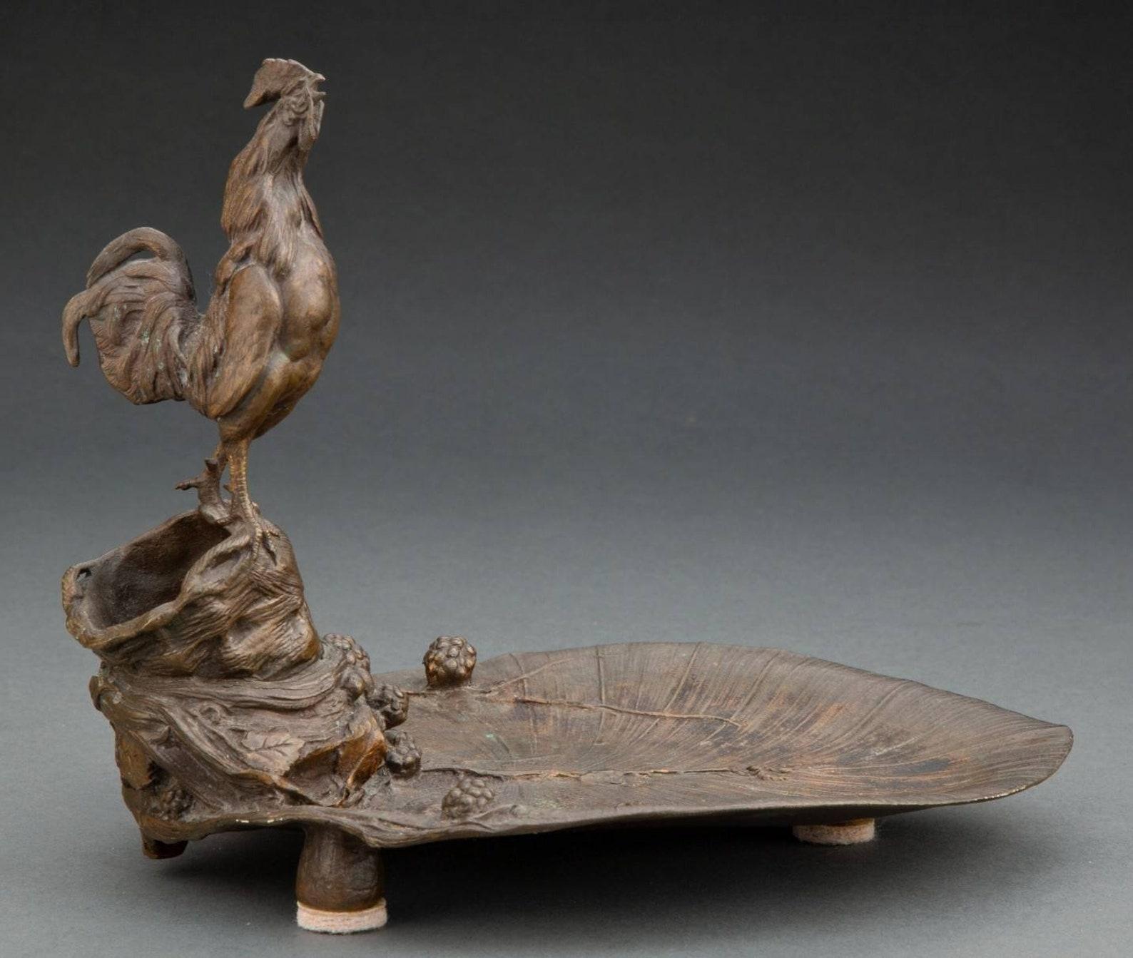 A very fine Auguste Nicolas Cain (French, 1822-1894) bronze sculpture depicting a crowing rooster perched atop naturalistic base of stylized log over large leaf form dish, decorated with blackberries.

Bronze with golden brown patina
circa 1880;
