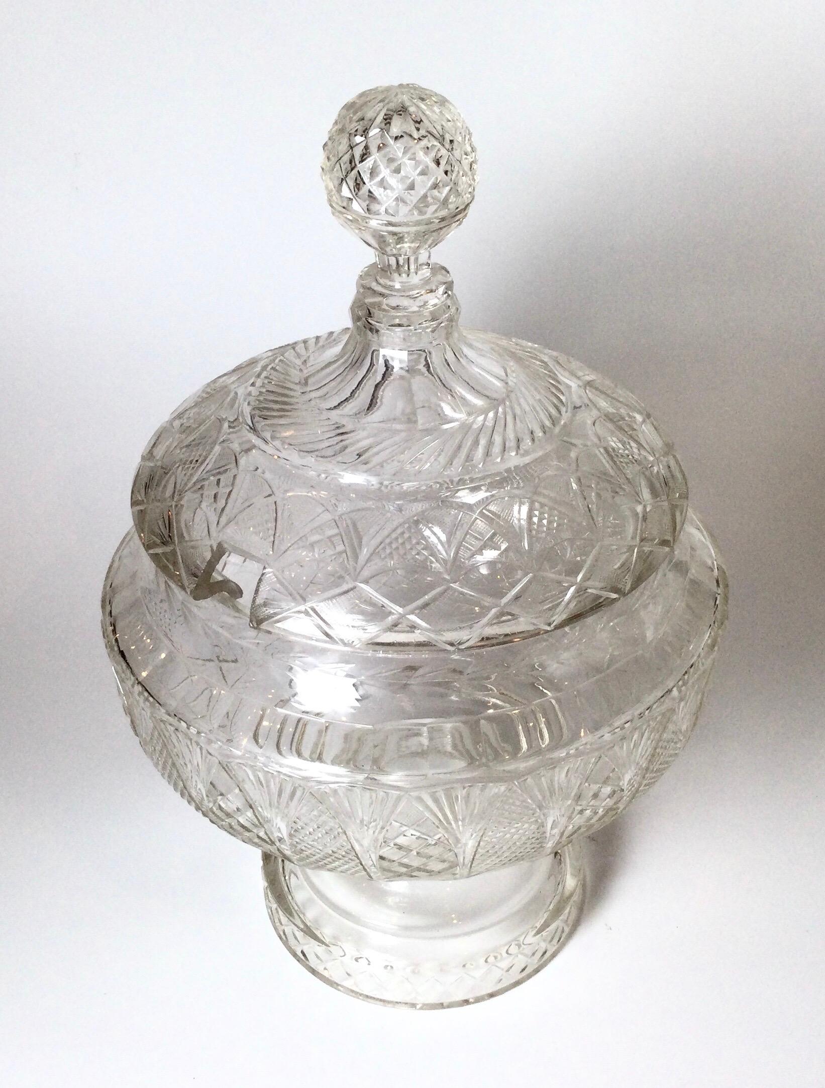 Extraordinary large cut glass punch bowl centerpiece on pedestal base with lid. The lid with diamond cut ball finial rests on a shapely detailed cut glass bowl with round pedestal base, this is all hand cut glass on a cutting wheel and not pressed,
