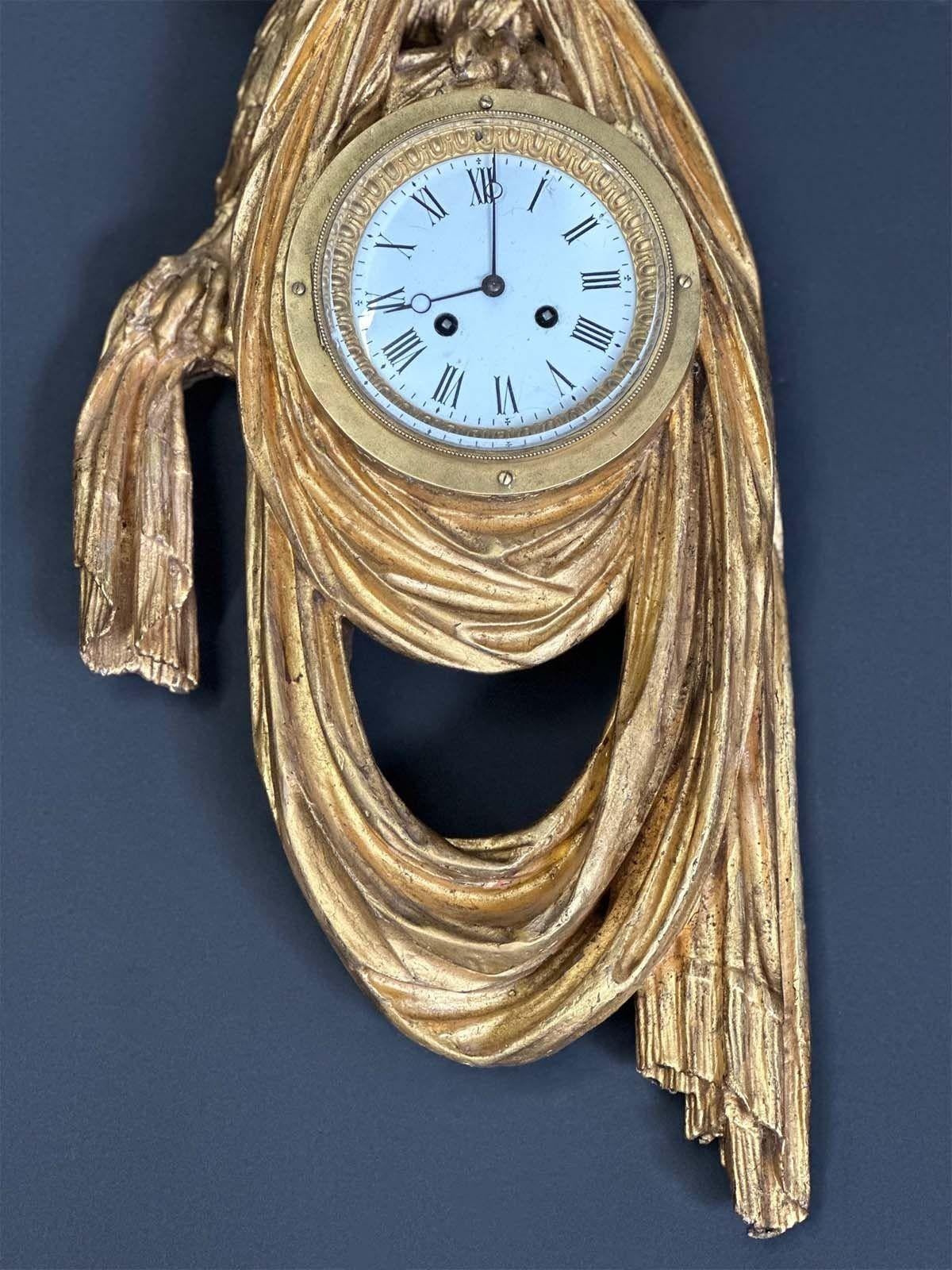 Pendule en bois doré sculpté à la main de l'Empire autrichien représentant un aigle tenant un morceau de tissu. Au centre de la pièce se trouve une horloge avec des chiffres romains. Fabriqué en Autriche, vers le 19e siècle. 
Dimensions :
30 